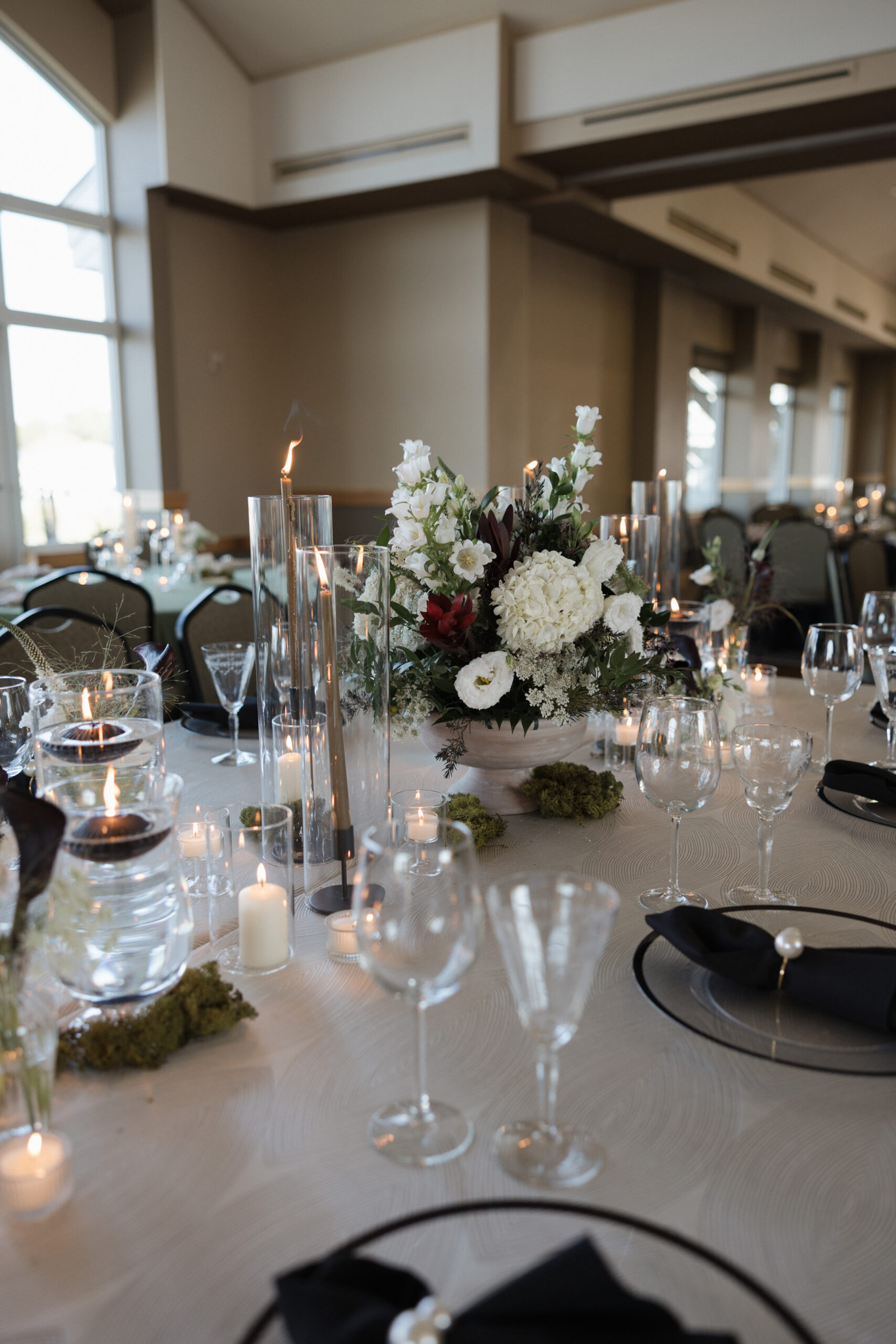 Black and white wedding table setup at indoor wedding reception