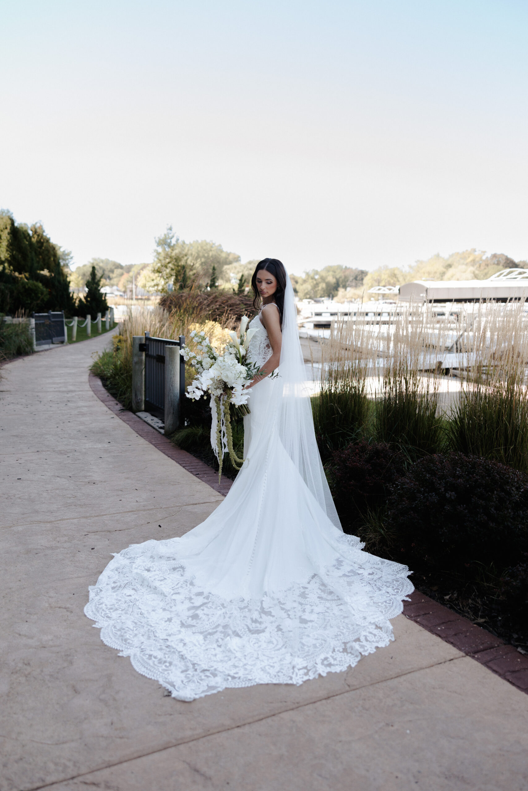 Bride posing for a bridal portrait showing off her wedding dress train