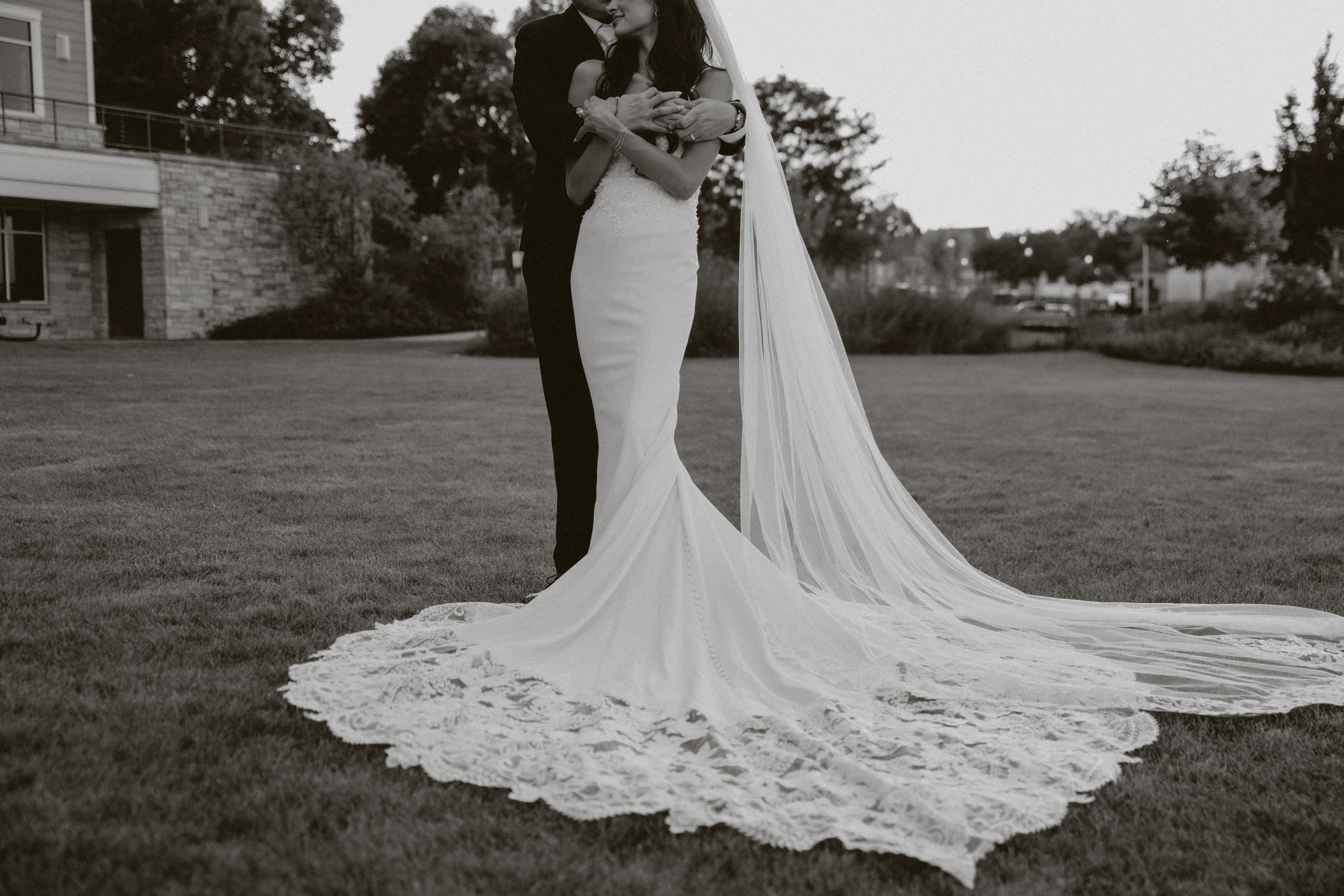 Editorial black and white wedding photo that shows off bride's wedding dress and veil