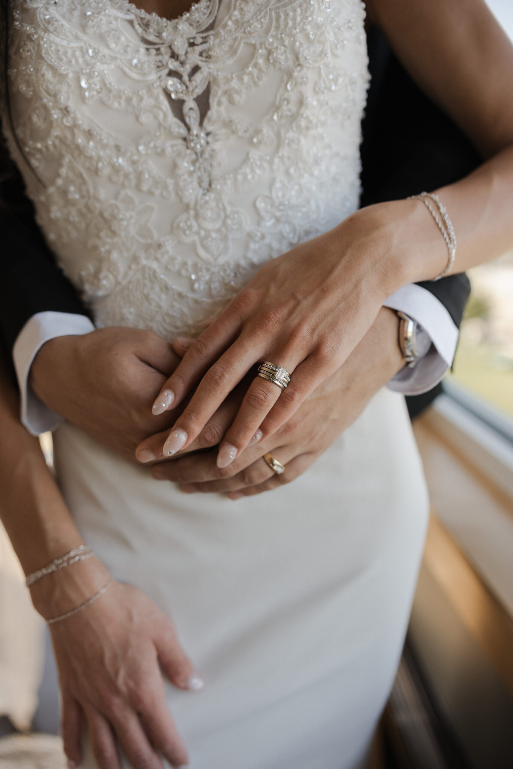 Bride and groom holding hands showing off their rings in a wedding photo