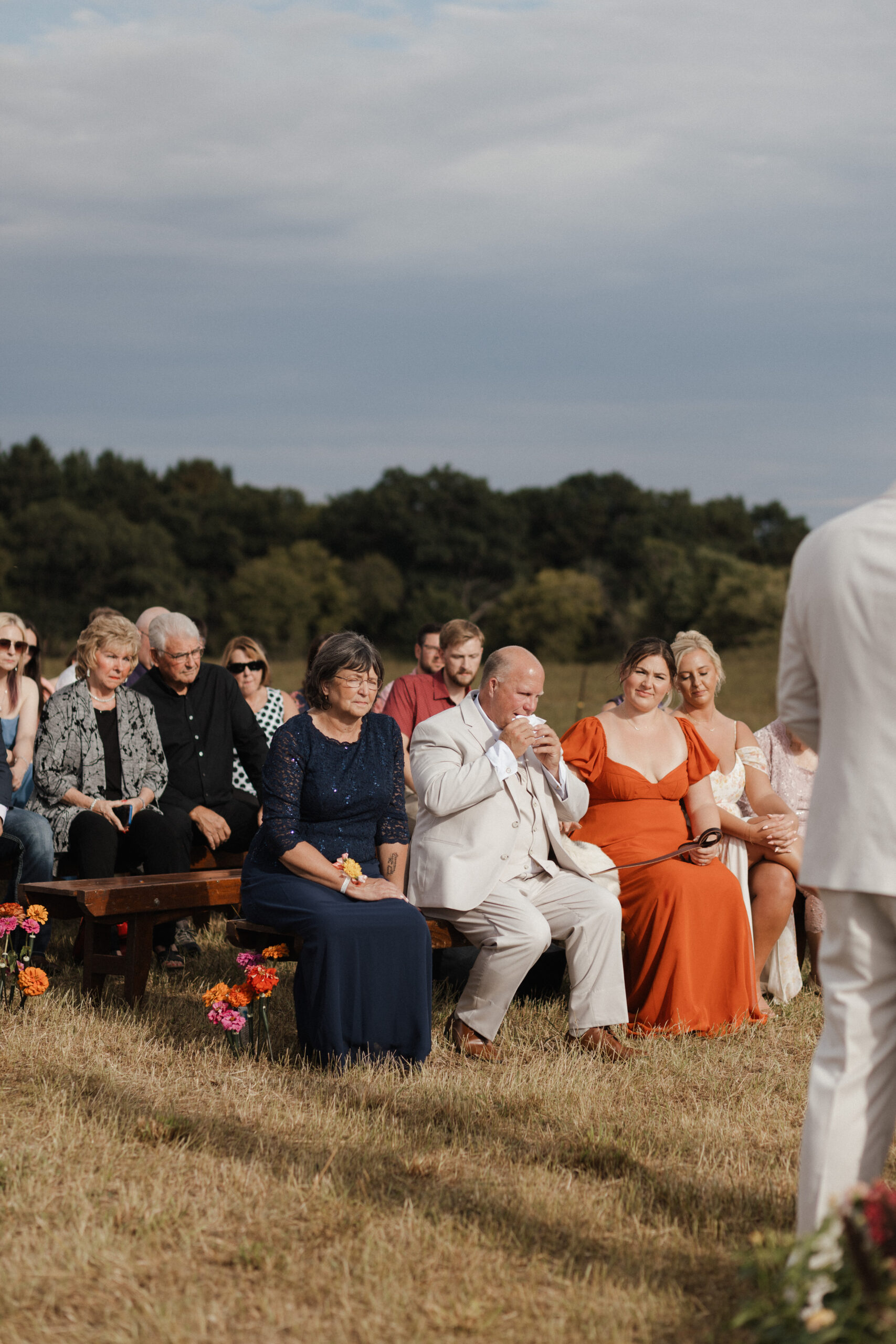 A father of the bride crying during a backyard wedding ceremony