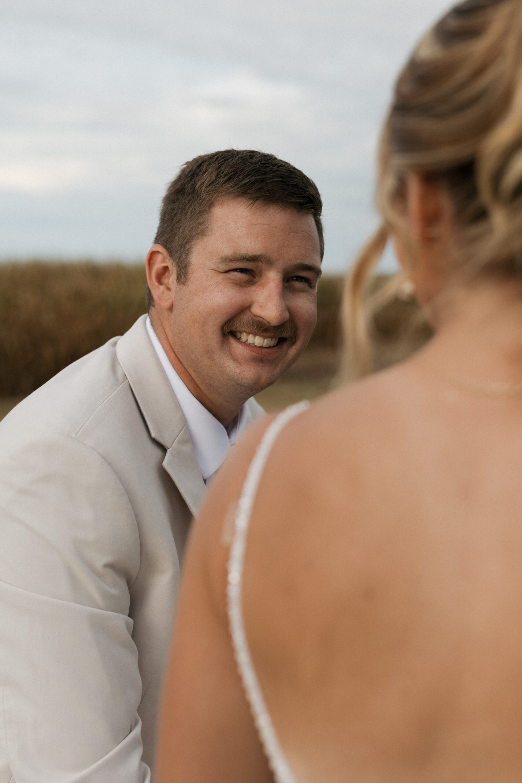 A groom laughing at his bride during wedding photos