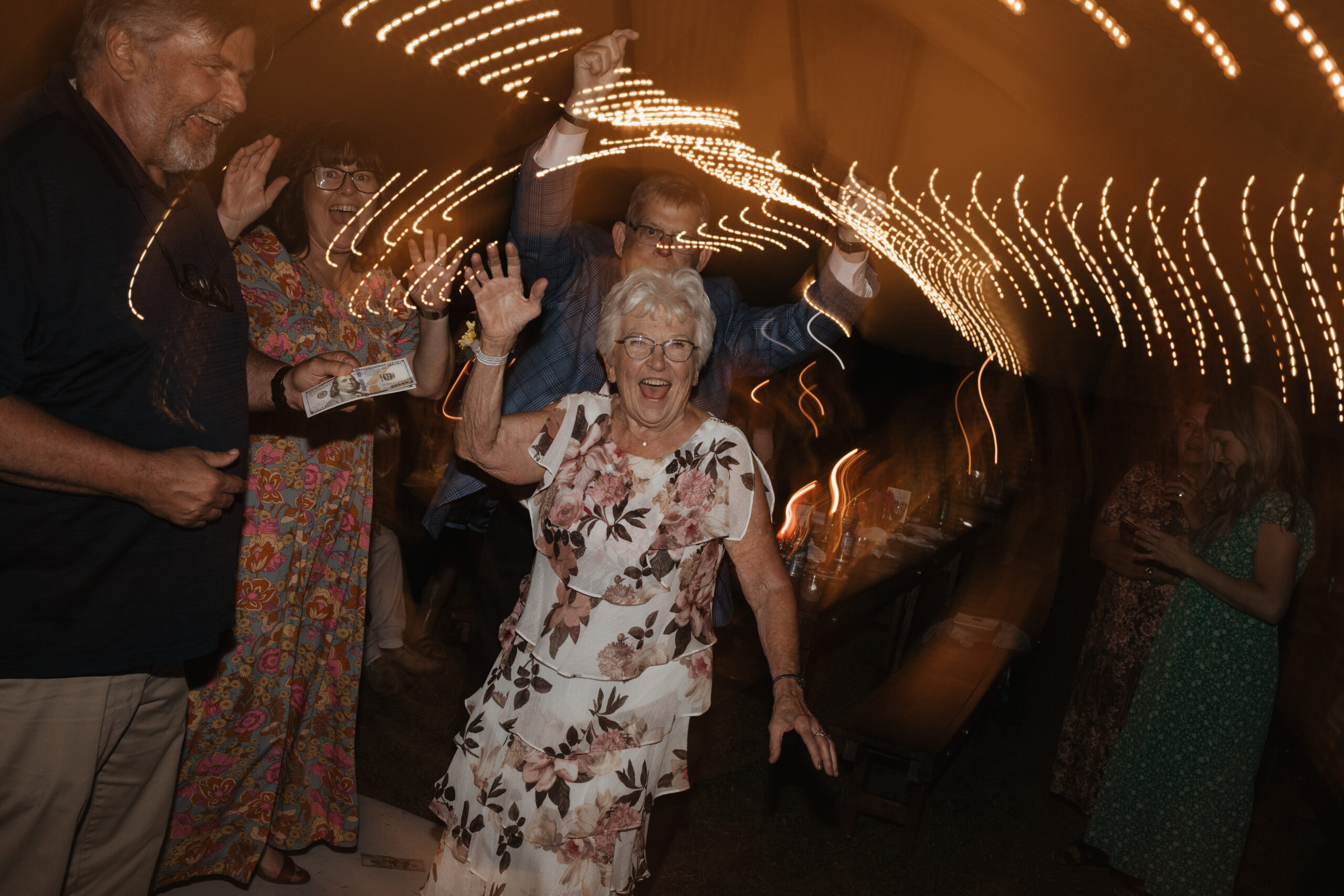 A blurry photo of a grandmother dancing on the dance floor at a backyard wedding