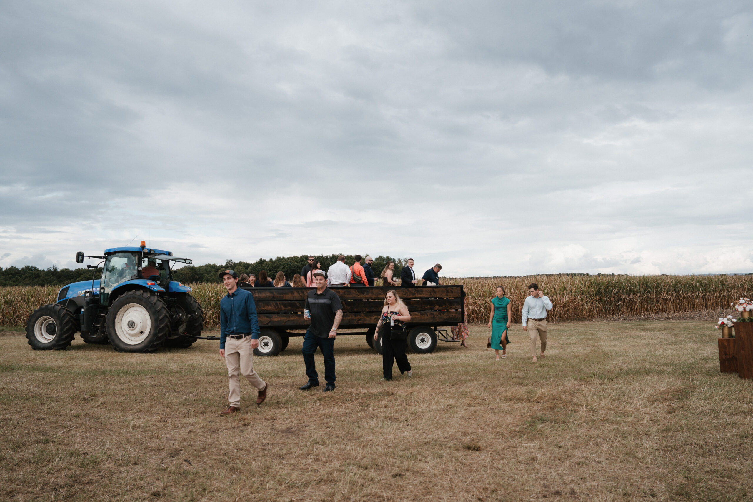 Wedding guests arriving to a backyard wedding on a tractor