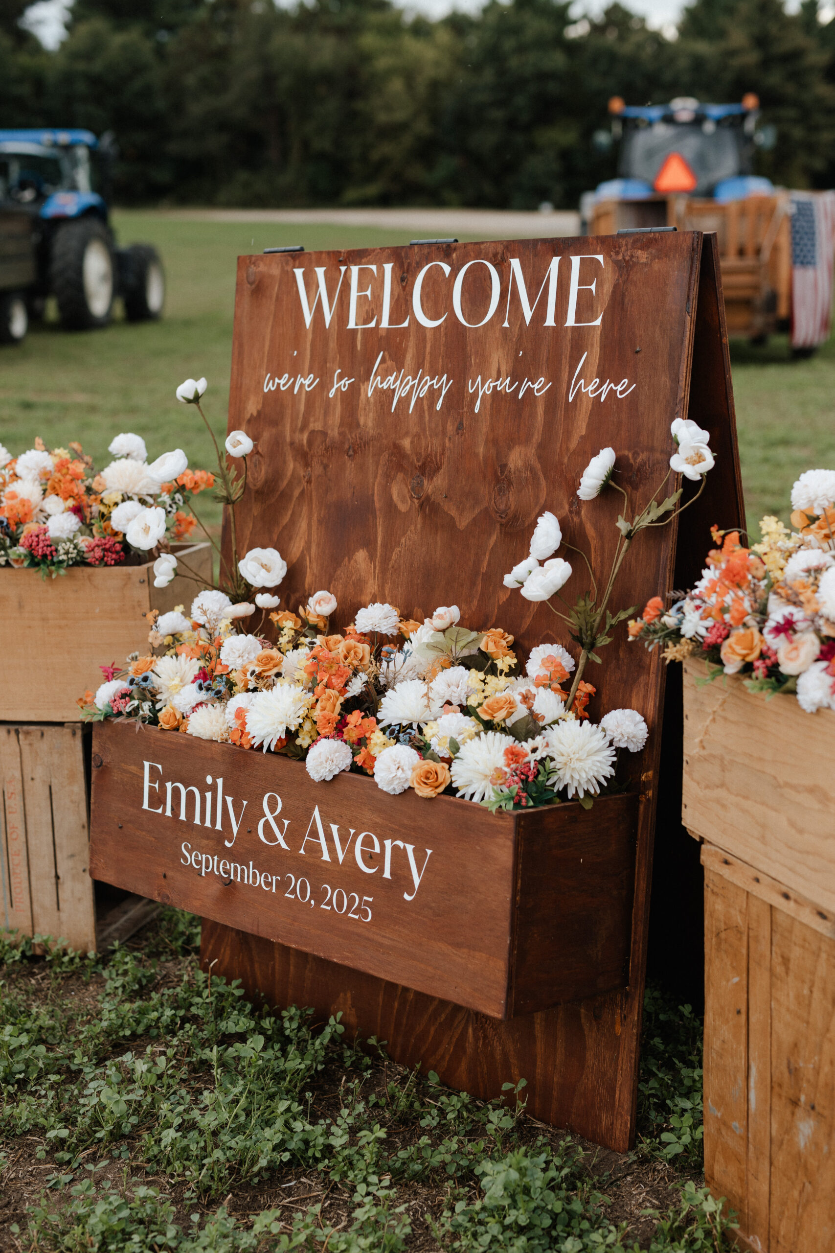 A wedding welcome sign made out of wood with orange and white flowers