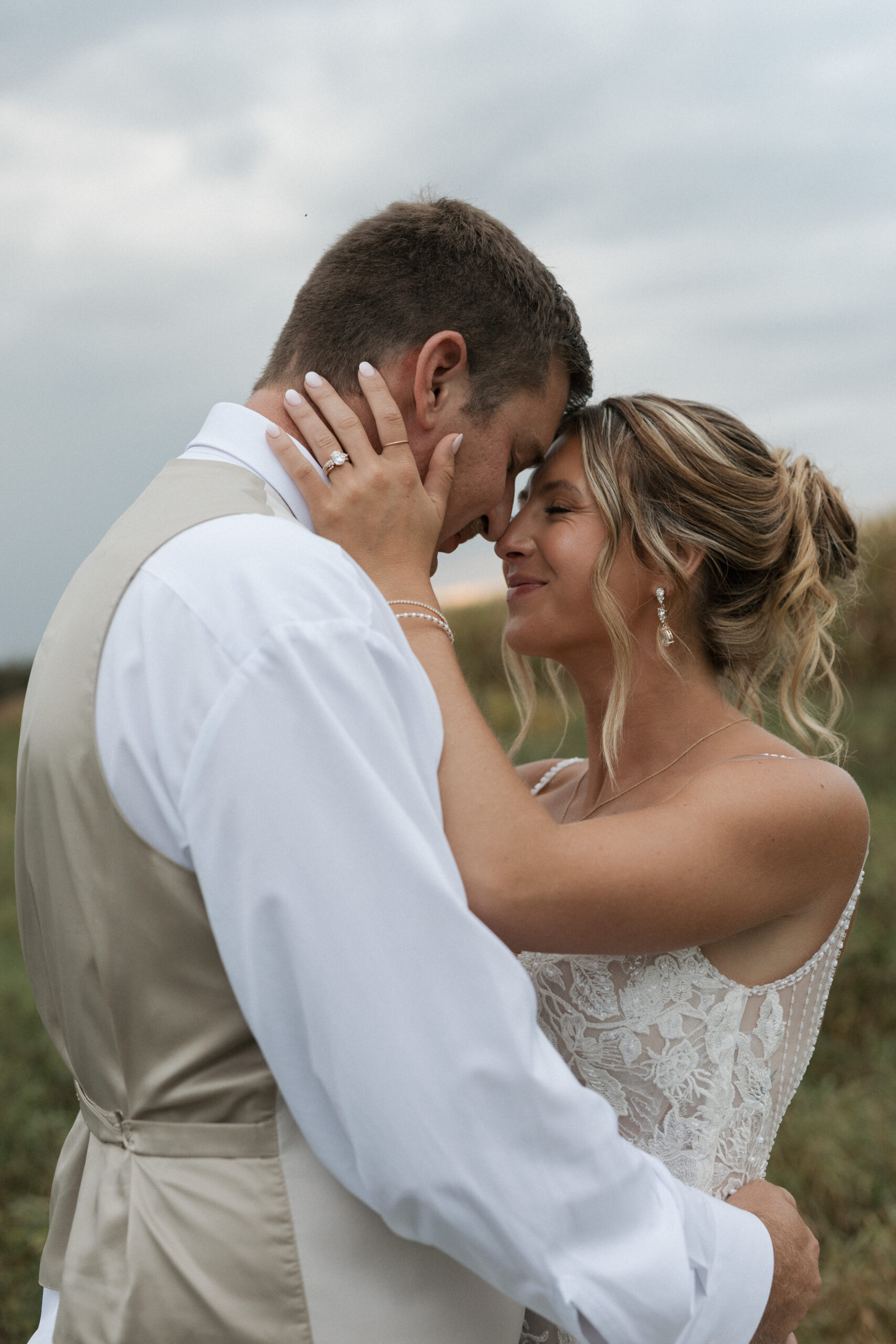 A couple touching foreheads in a romantic wedding photo from their backyard wedding