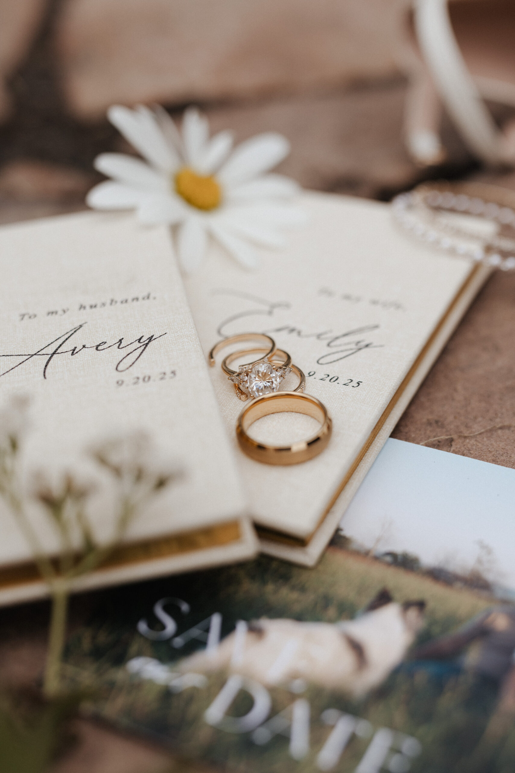 Wedding details, including vow books and wedding rings, from a backyard wedding