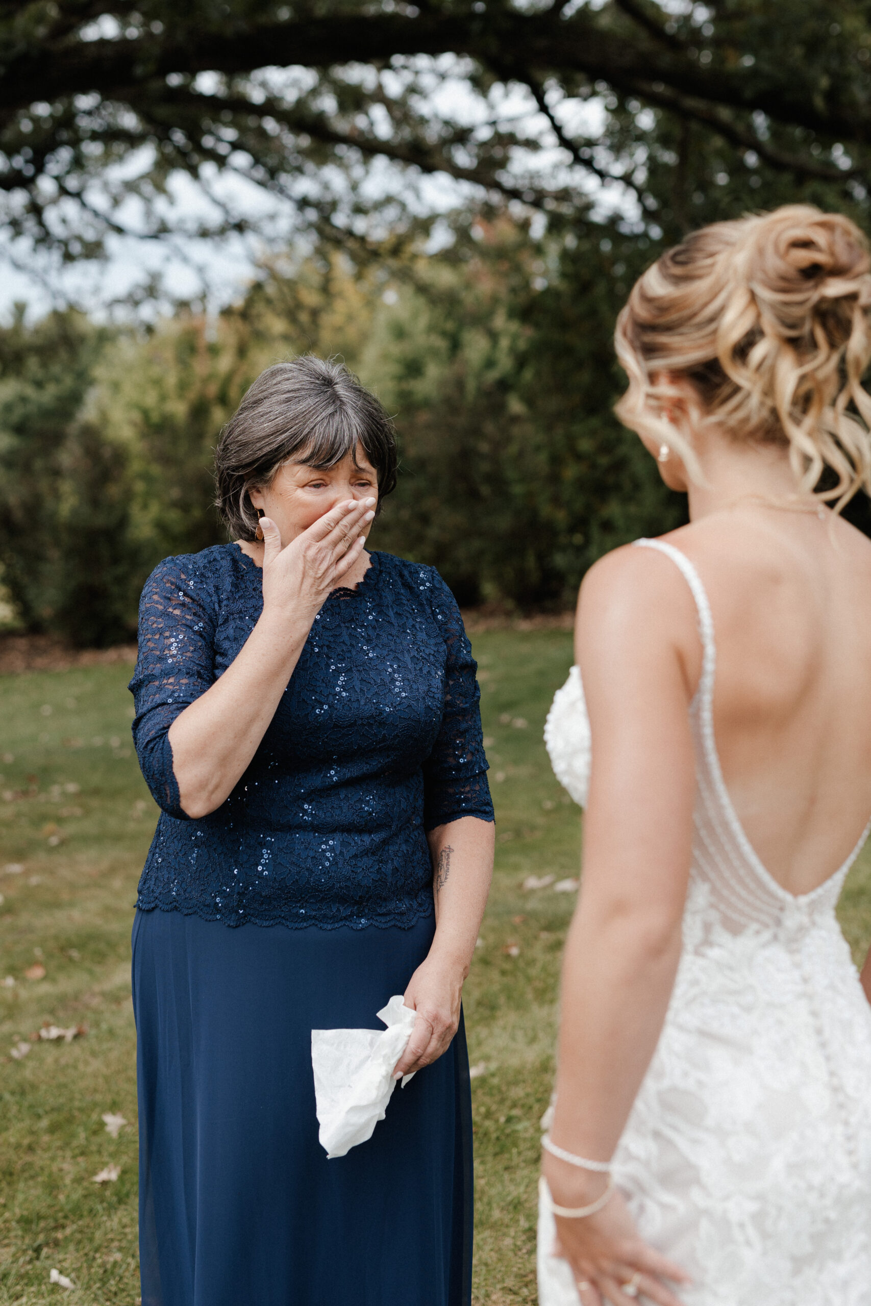 A bride's mother crying during wedding first look photos