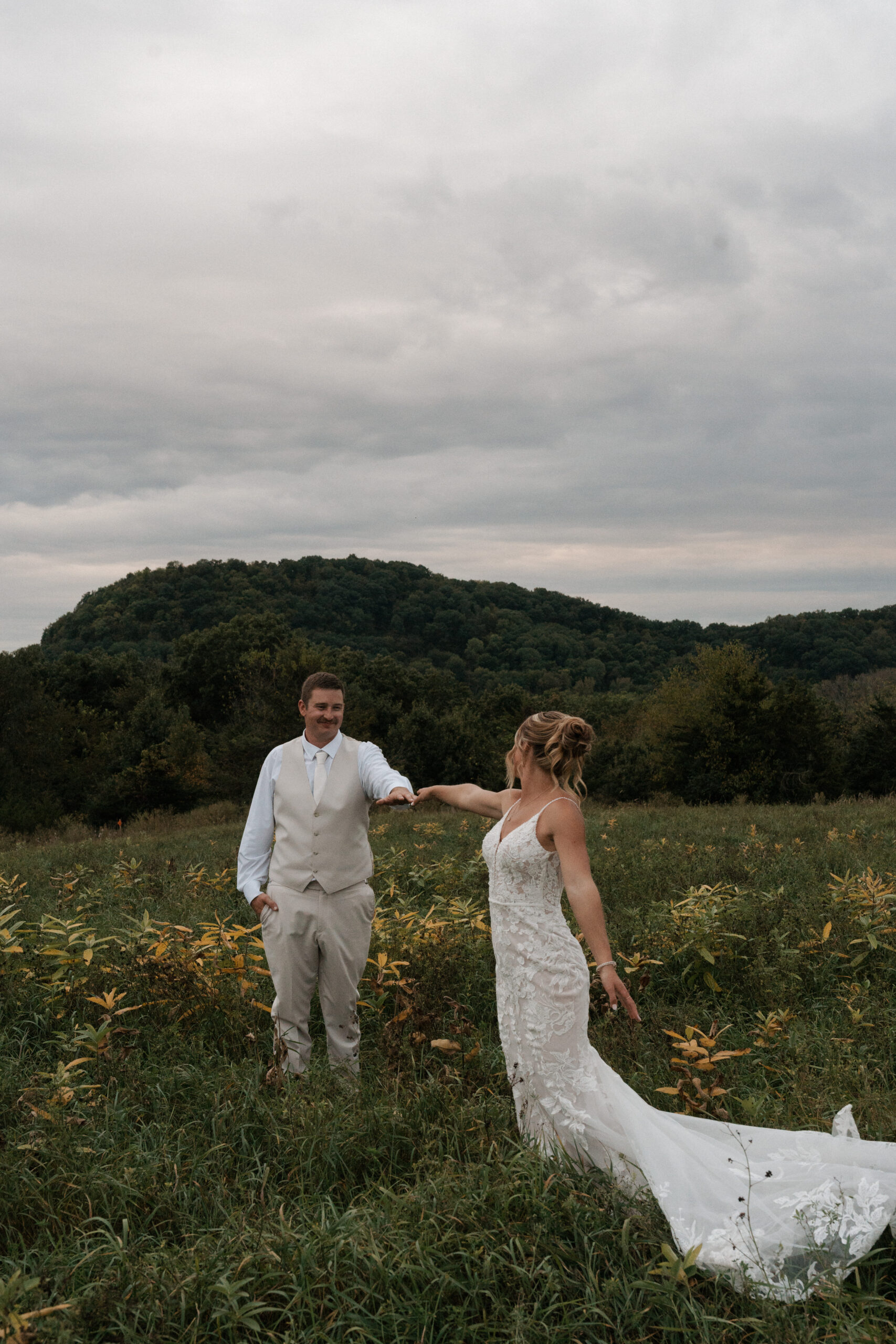 A couple reaching for each other during sunset wedding photos