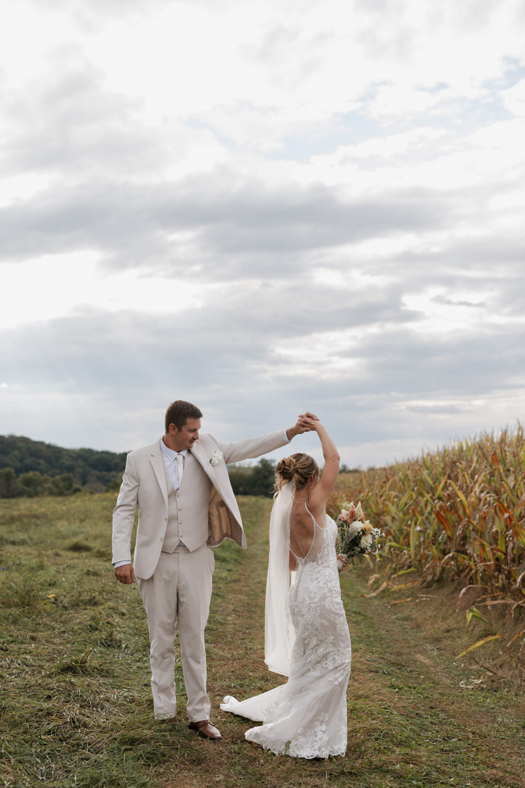 A groom spinning his bride for photos from their backyard wedding