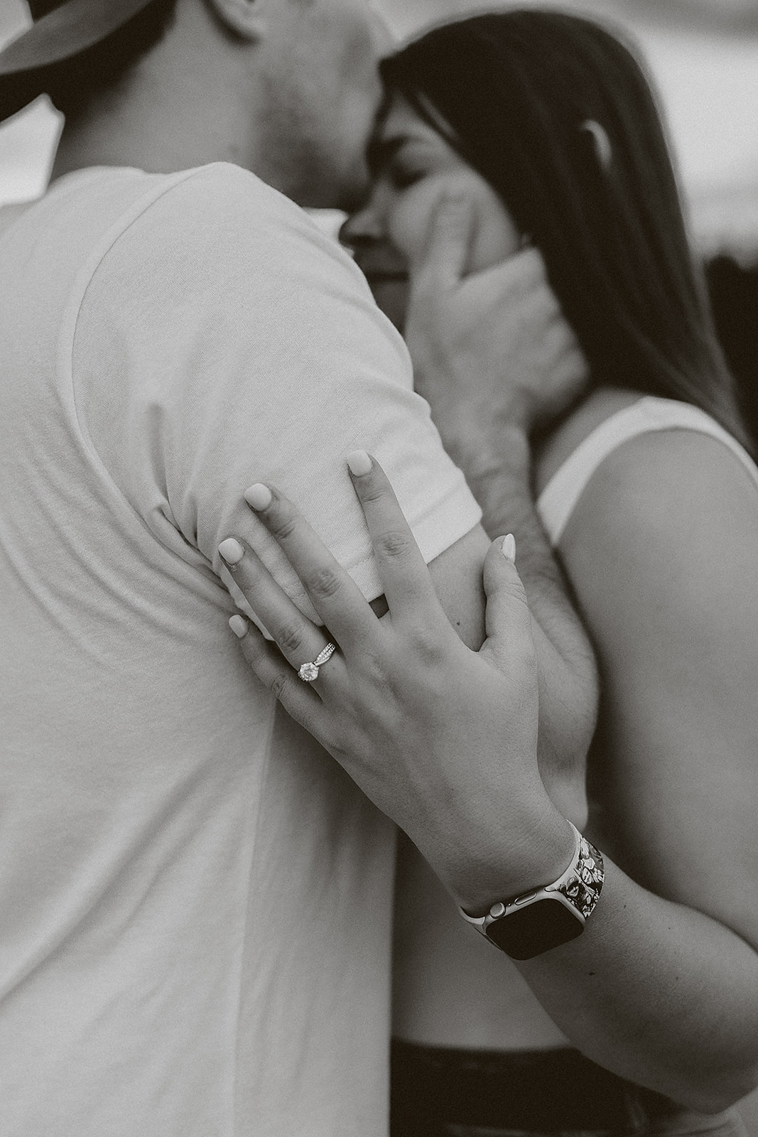 A man kissing his fiancee on the forehead during engagement photos