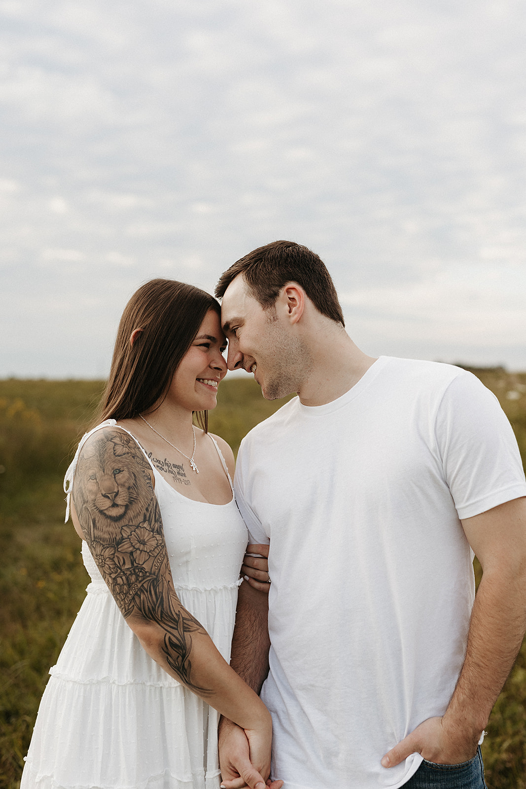A couple standing with their foreheads touching for engagement photo ideas