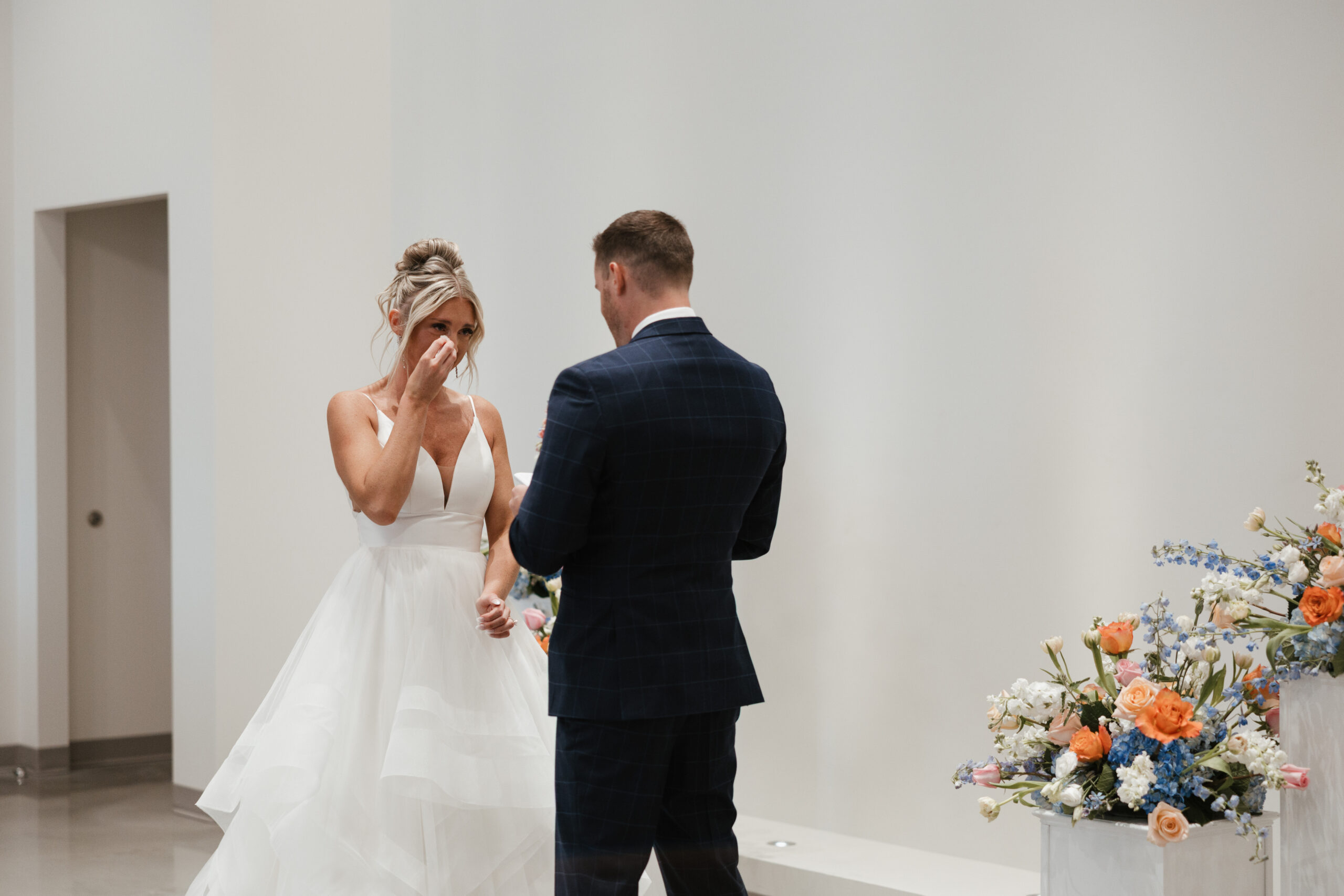 A bride crying during wedding first look photos with her husband