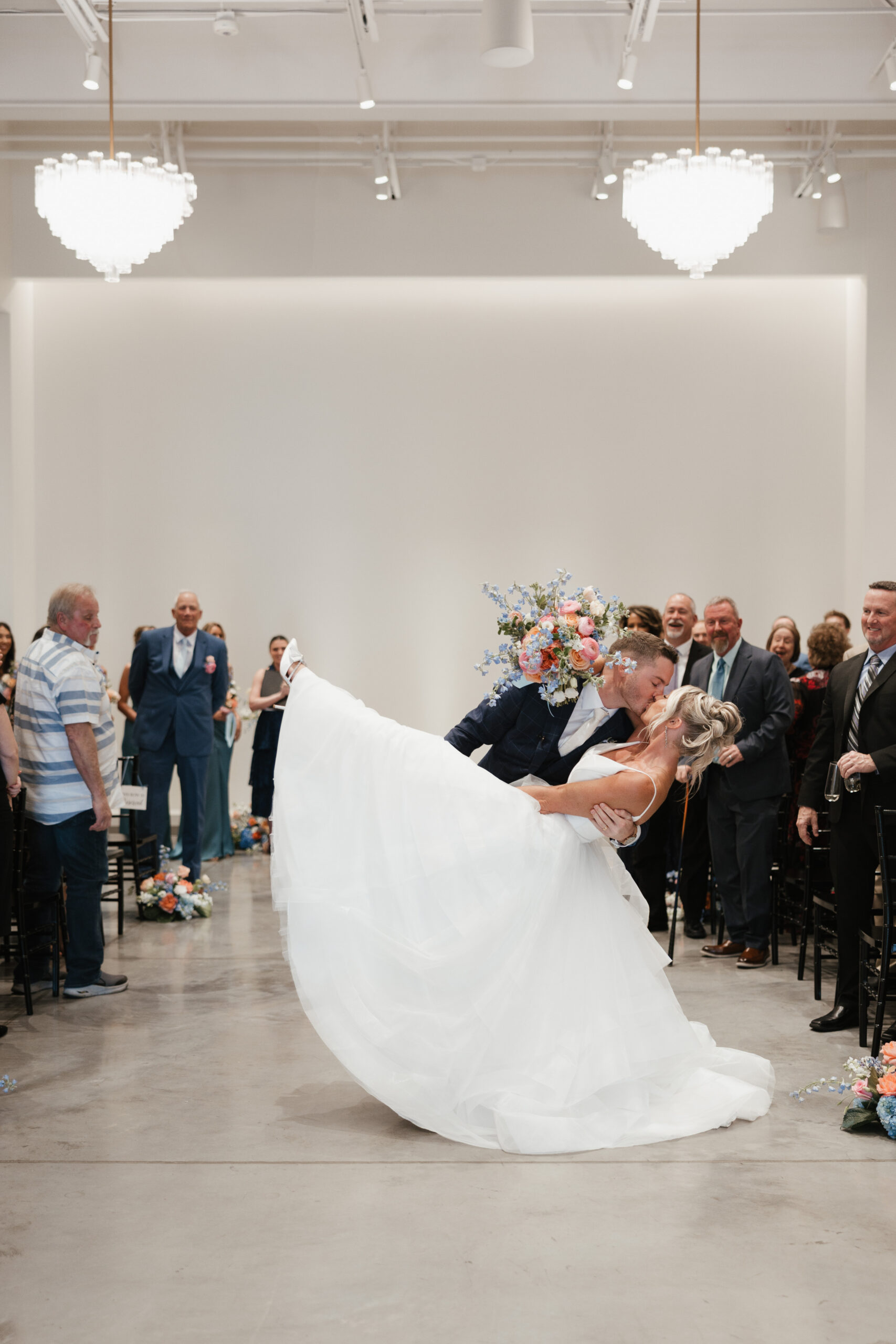 A couple kissing after exiting their ceremony 