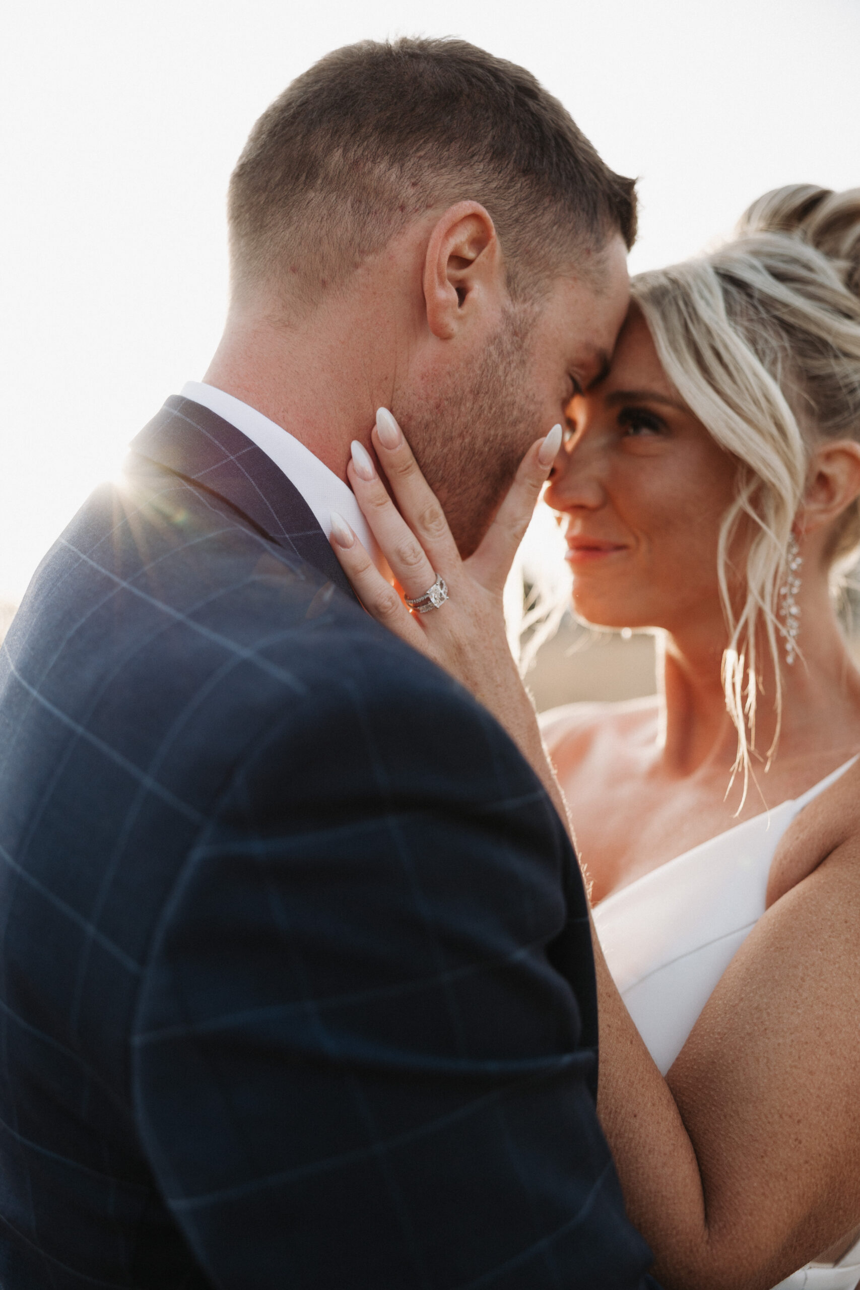 A bride and groom touching foreheads during sunset wedding photos at The Valerie