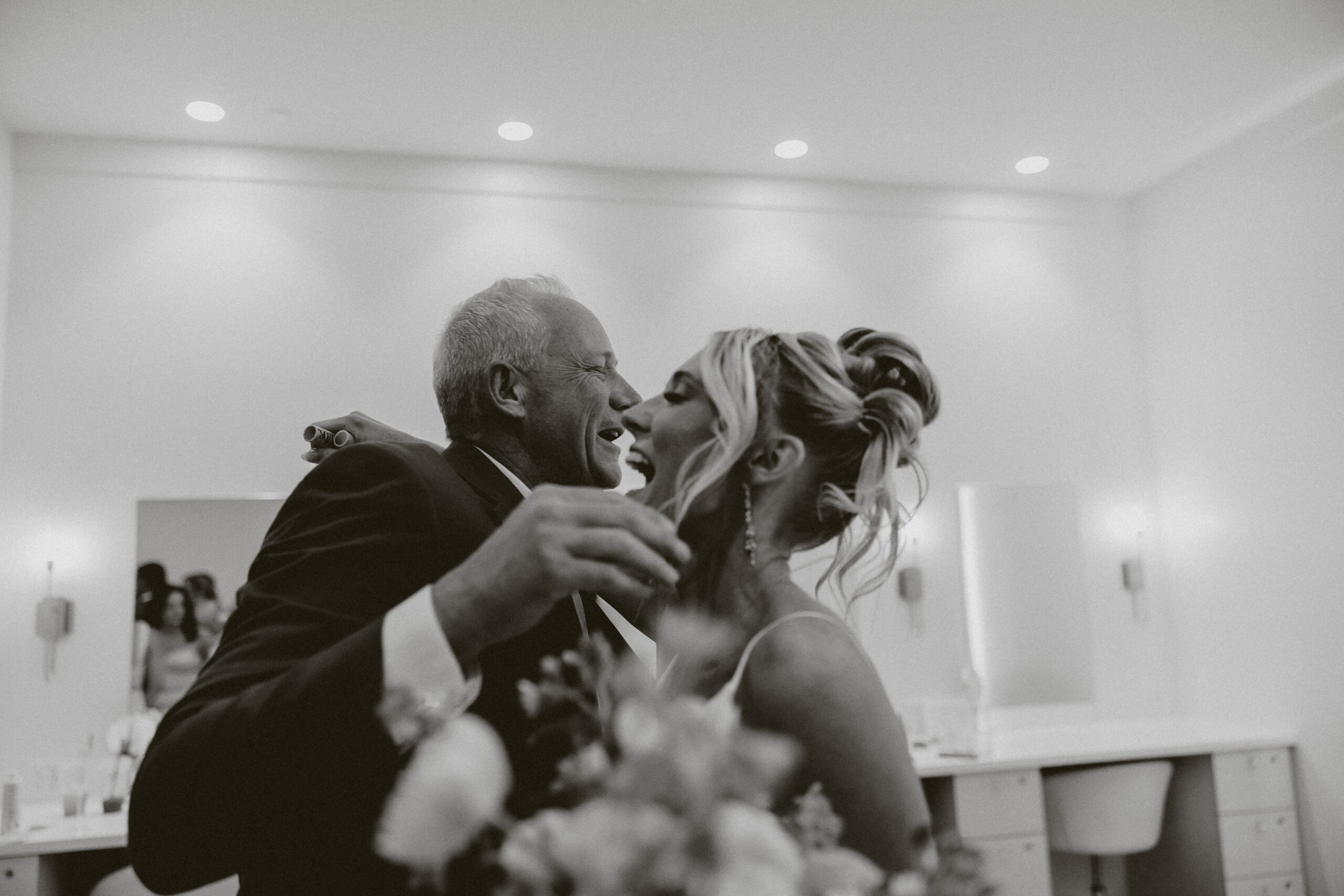 A bride hugging a wedding guest in a black and white photo at The Valerie