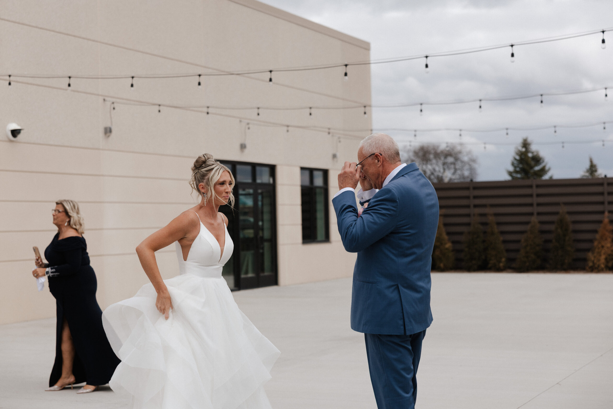 A bride and her dad crying during a wedding first look, during the wedding timeline