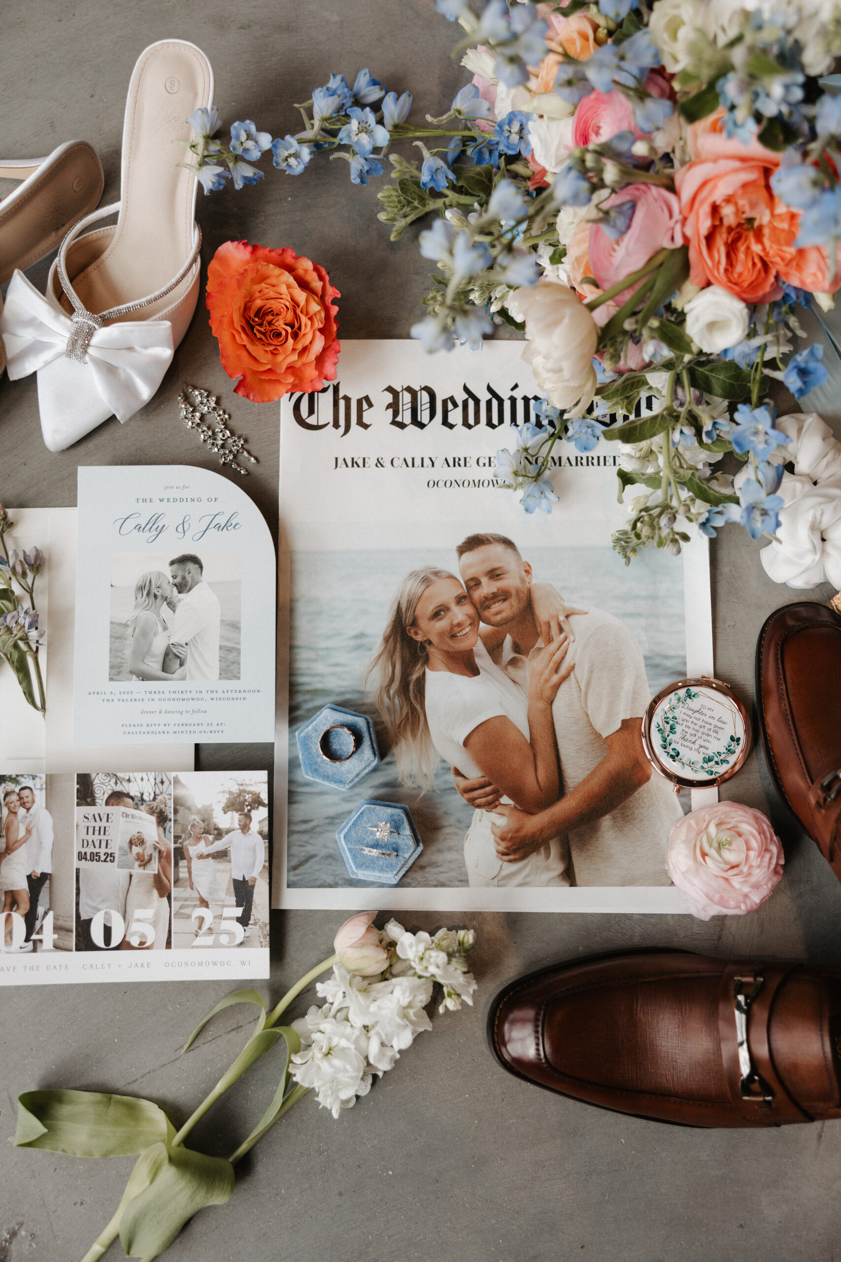 A wedding flat lay with wedding flowers, a wedding invitation suite, and bride and groom's wedding shoes