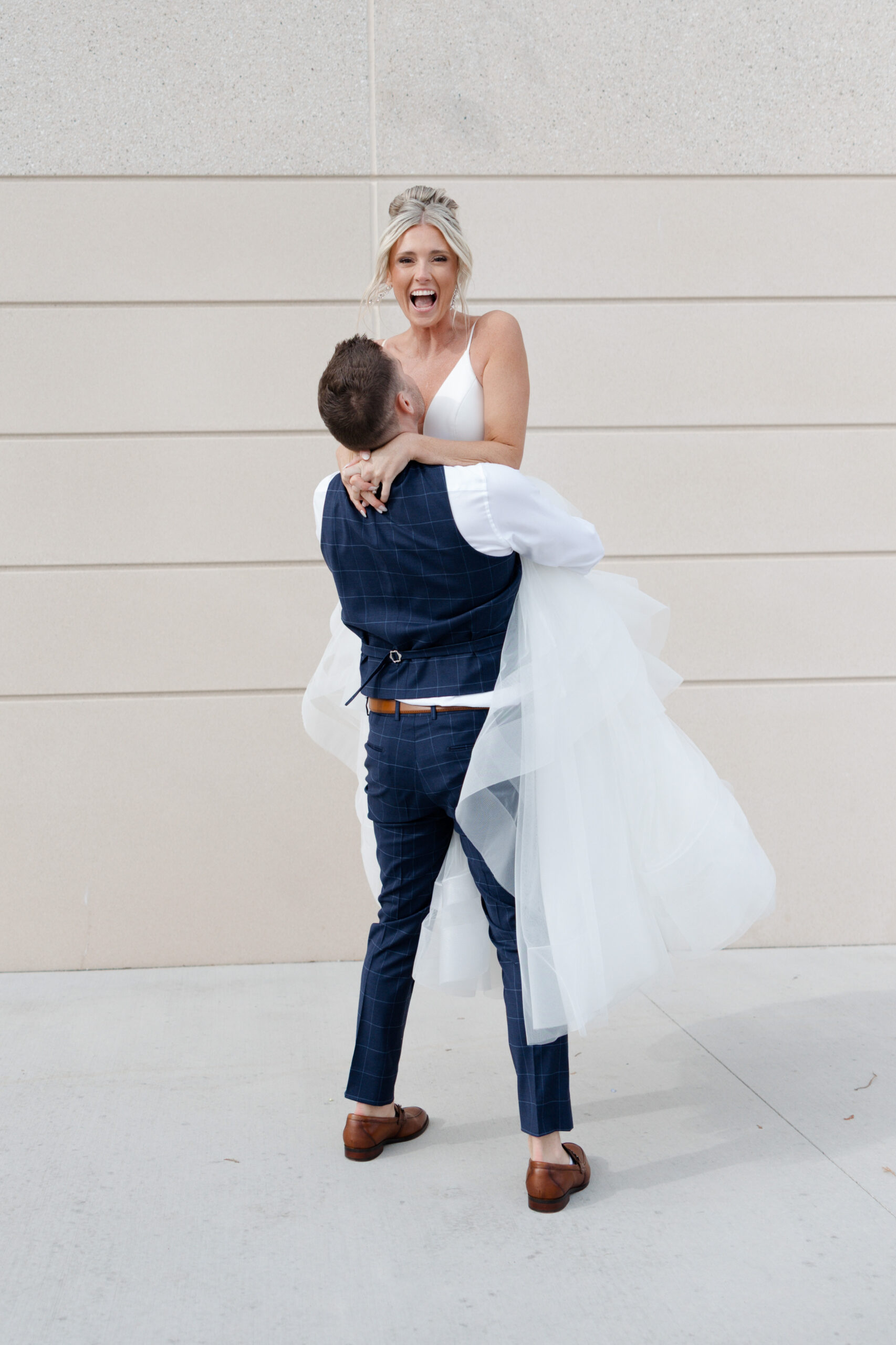 A groom lifting up a bride during wedding couple photos