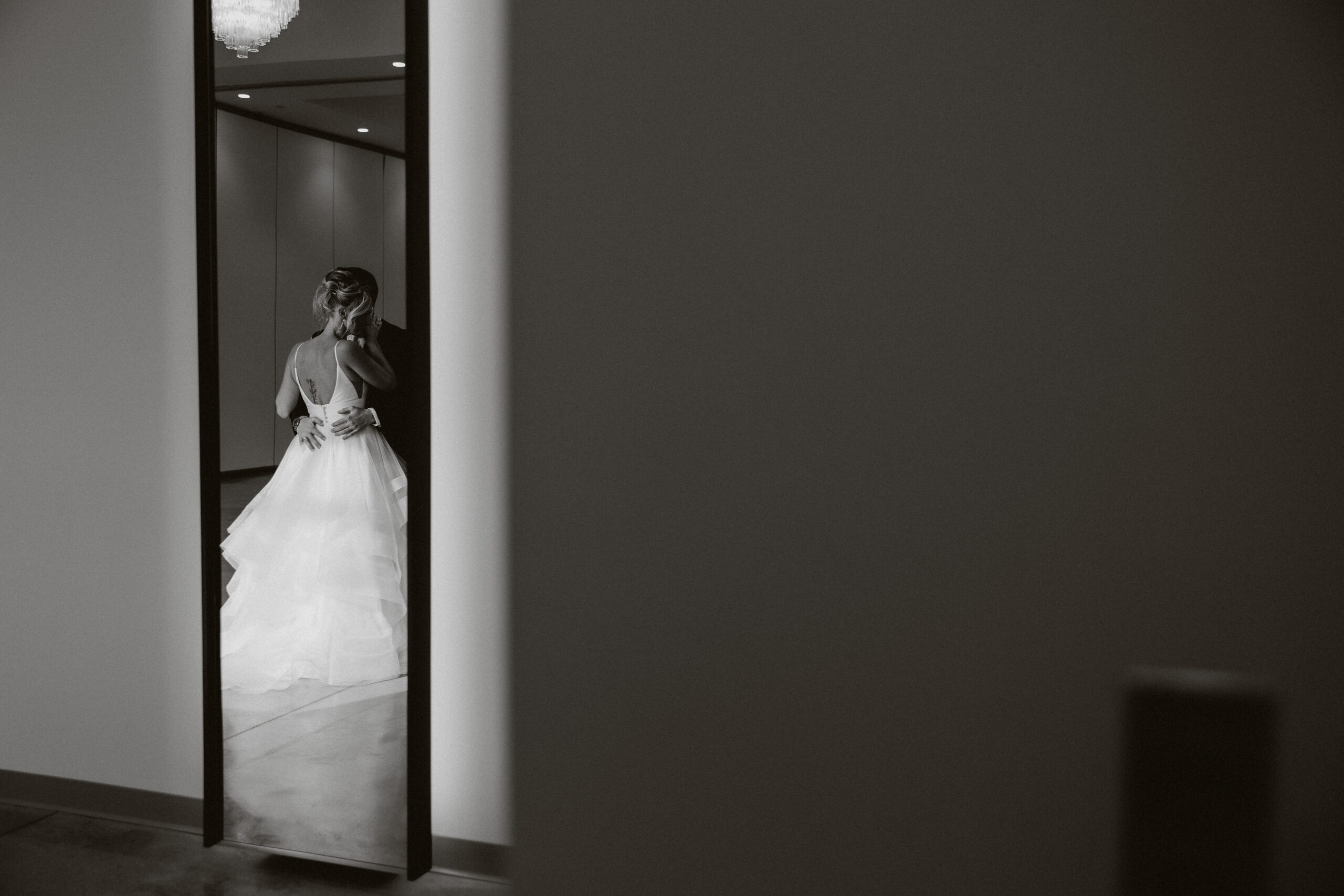 A black and white editorial photo of a bride and groom inside their wedding venue, the Valerie