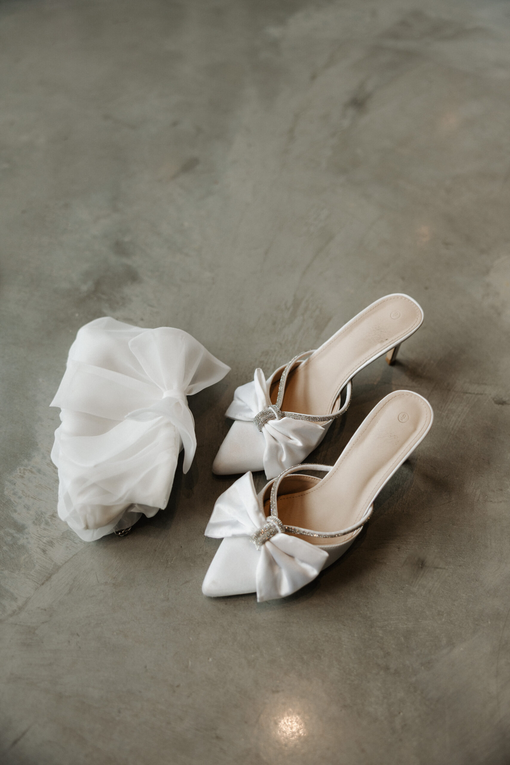 A bride's wedding shoes and purse on the floor of her modern wedding venue, The Valerie