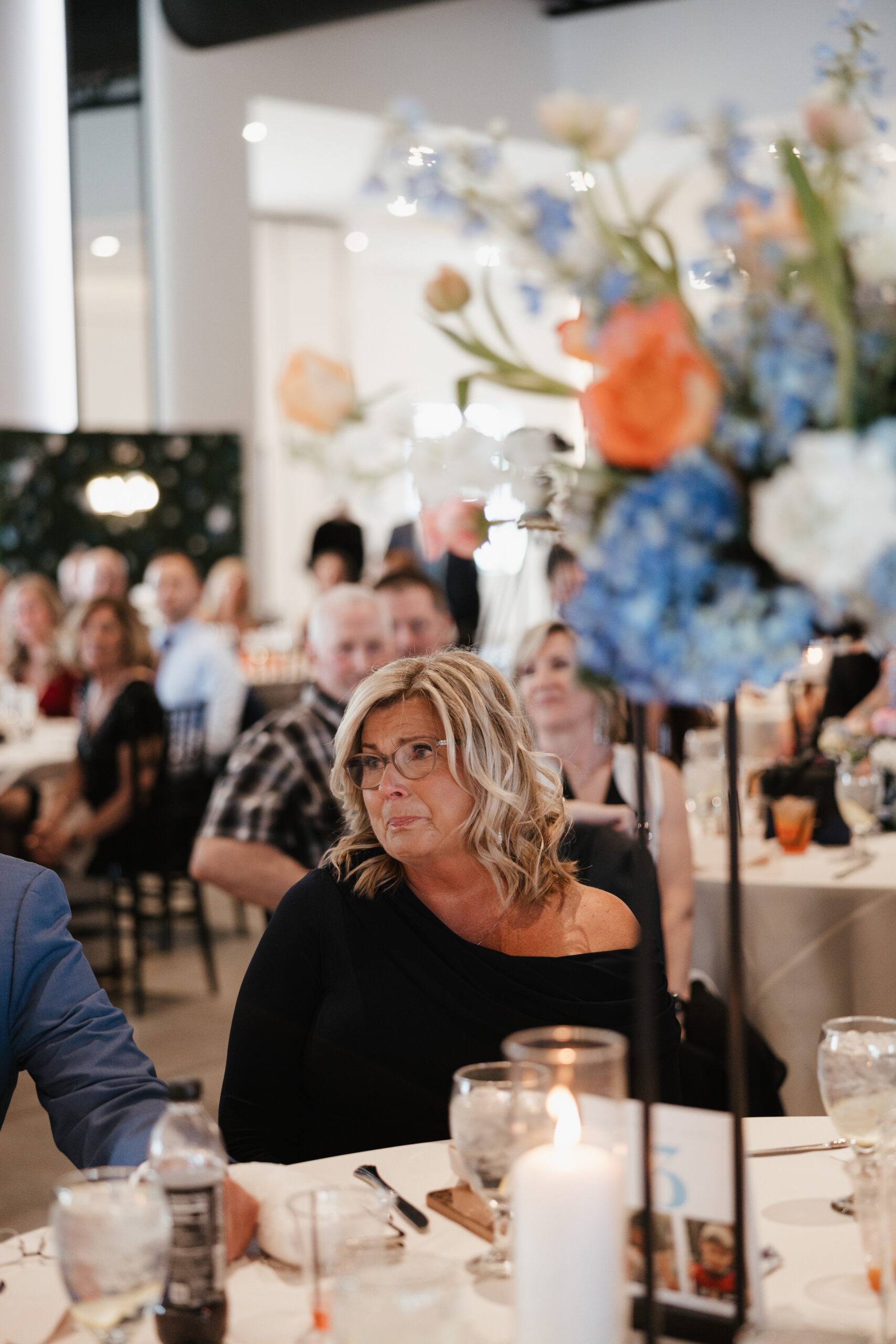 A candid wedding photo of a wedding guest crying during toasts