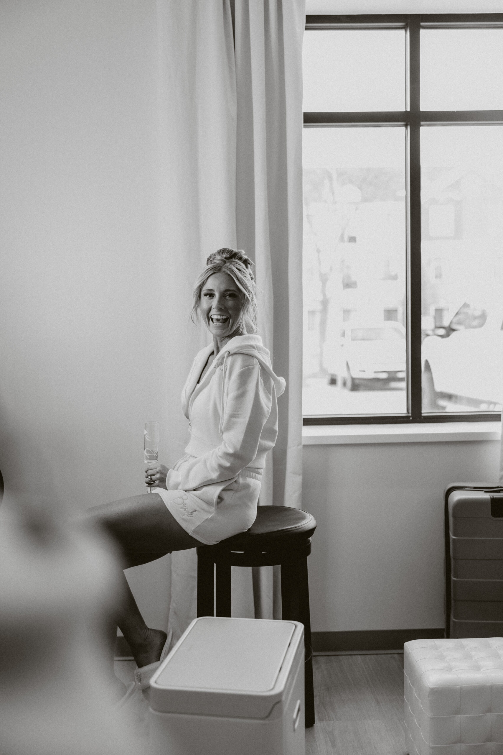 A candid photo of a bride laughing during getting ready photos