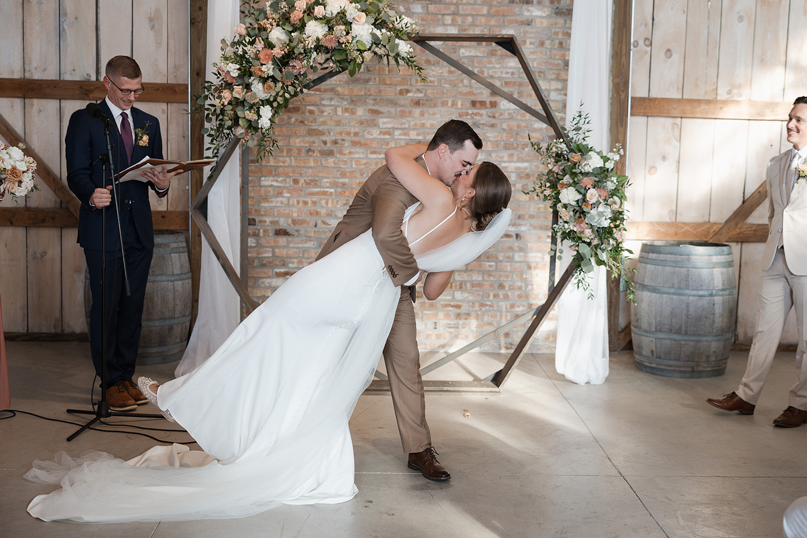 A couple sharing their first kiss in their wedding ceremony in a wedding blog post answering the question "how much does wedding photography cost?"