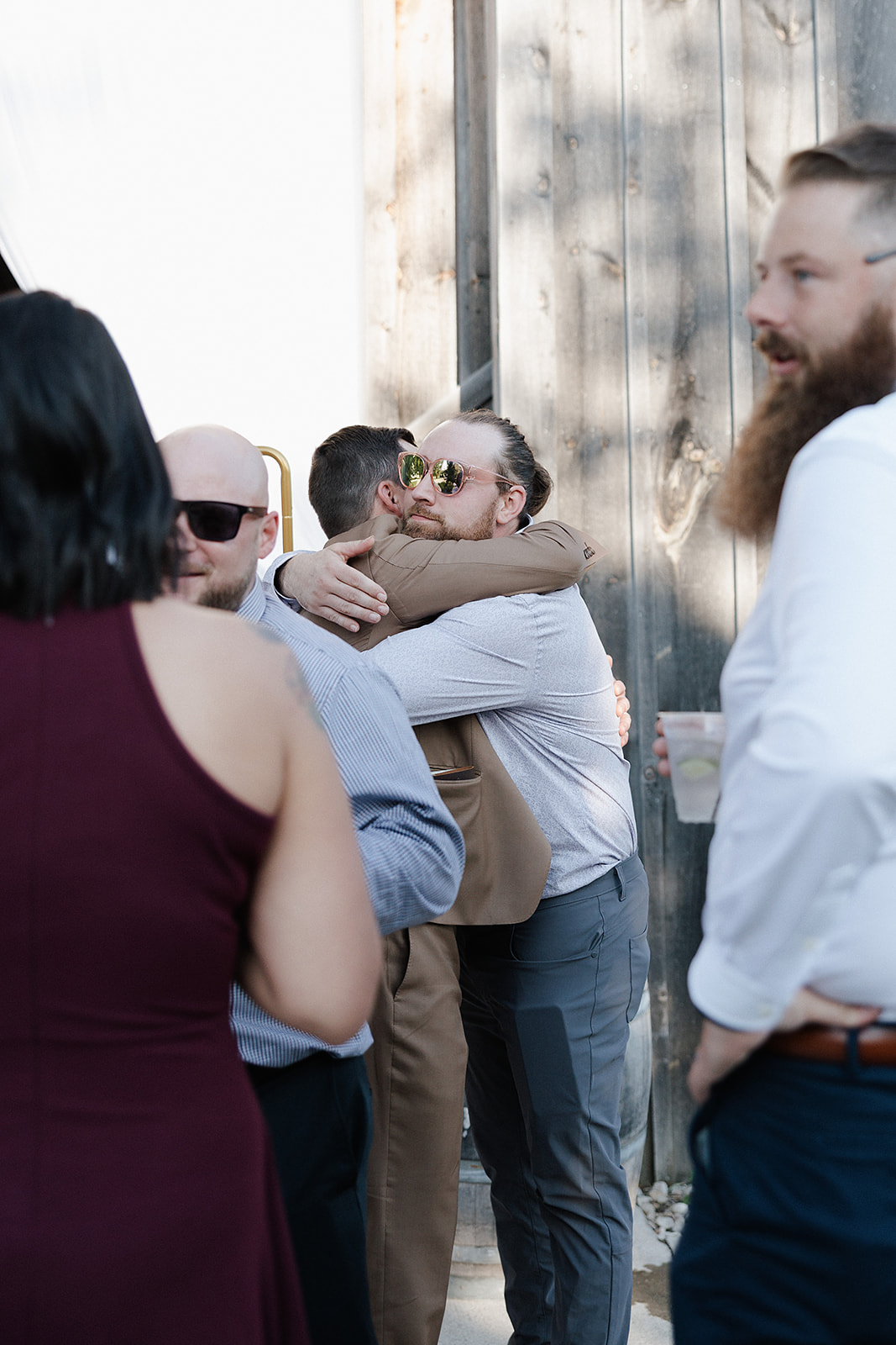 A groom hugging a wedding guest