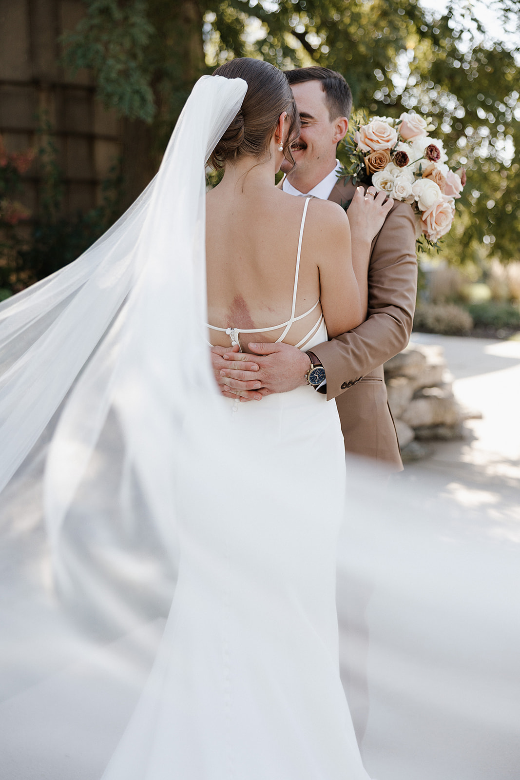 A bride and groom smiling at each other during wedding photos