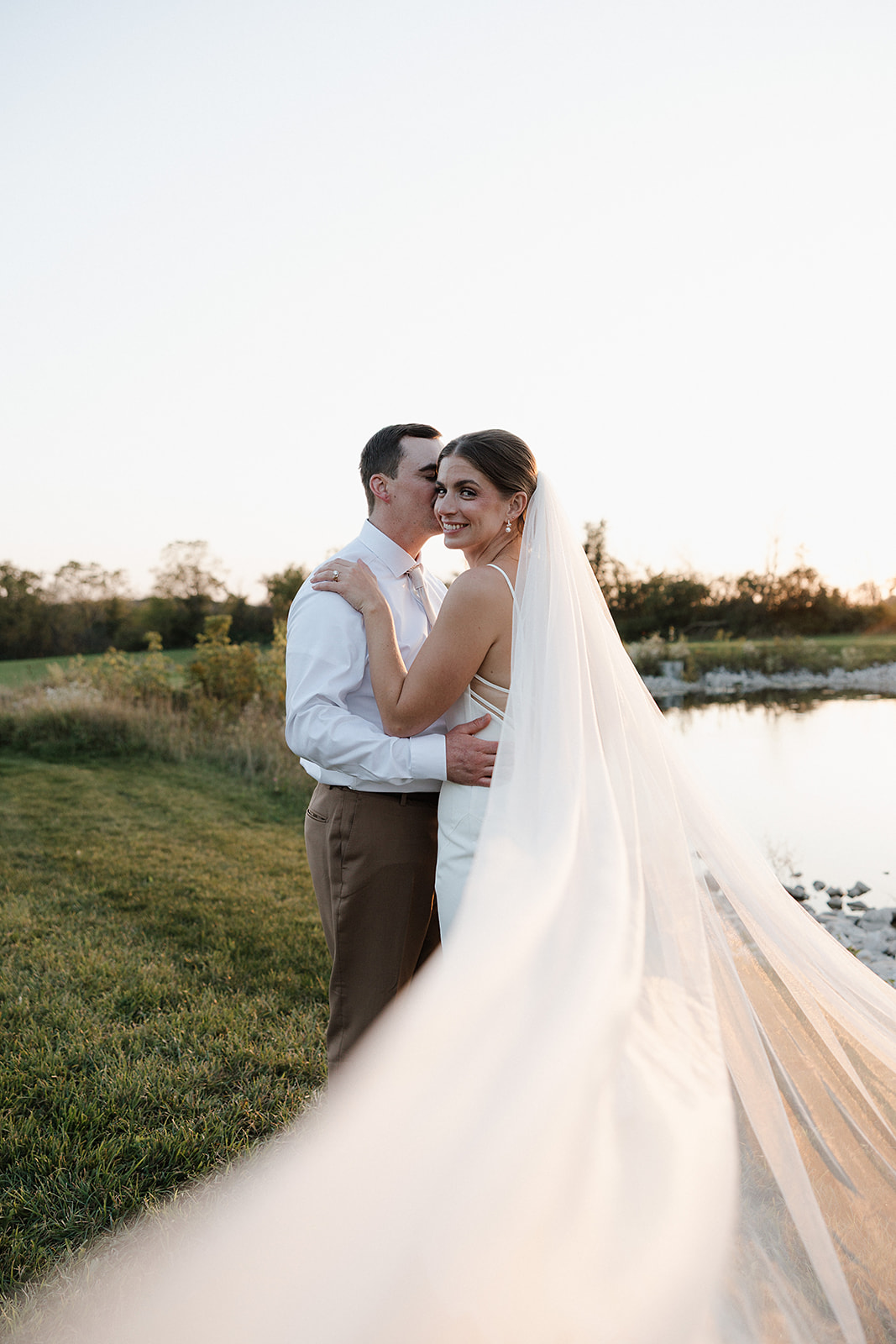 A bride and groom posing for sunset wedding photos