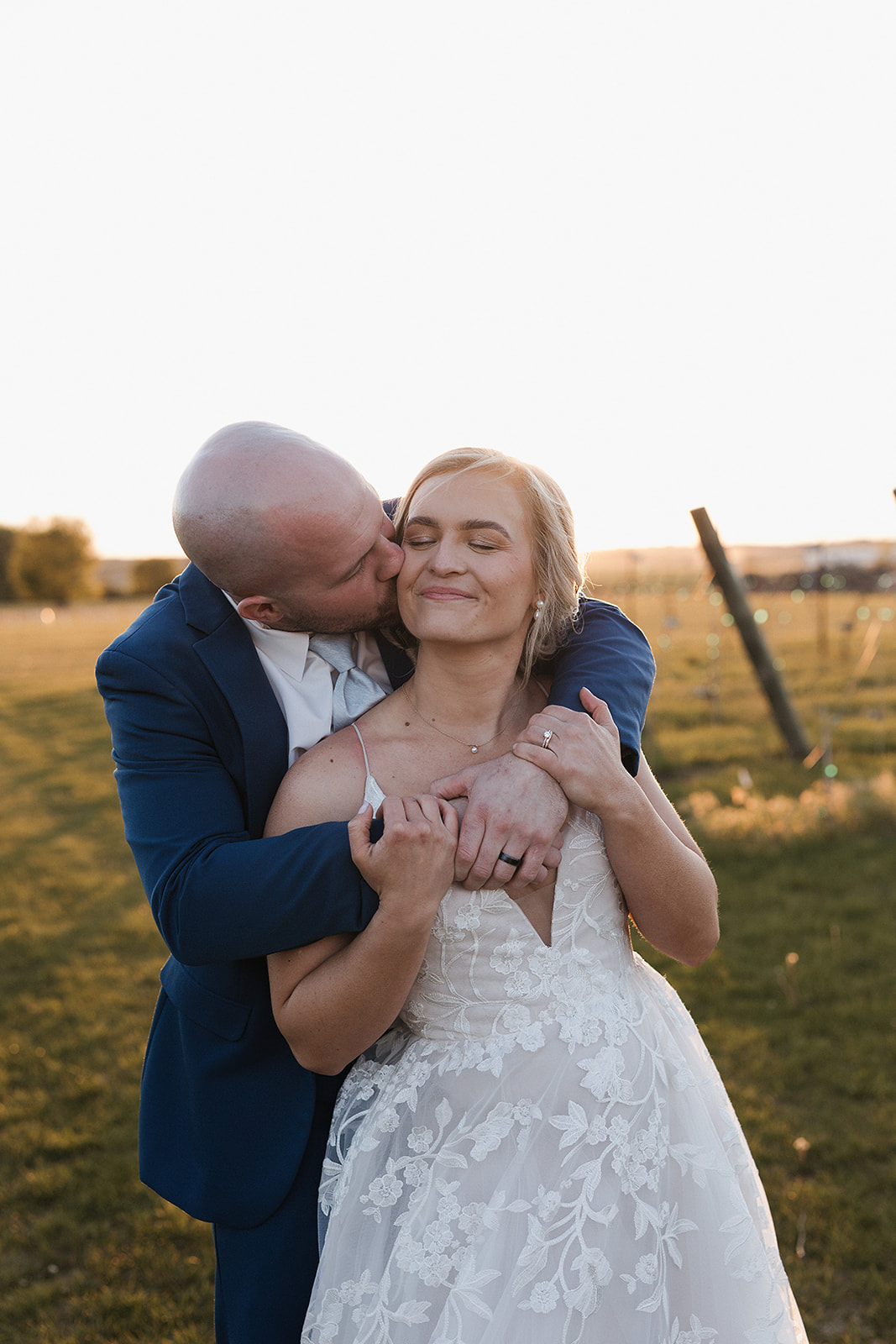 A bride and groom taking sunset photos at that spot in their wedding reception timeline