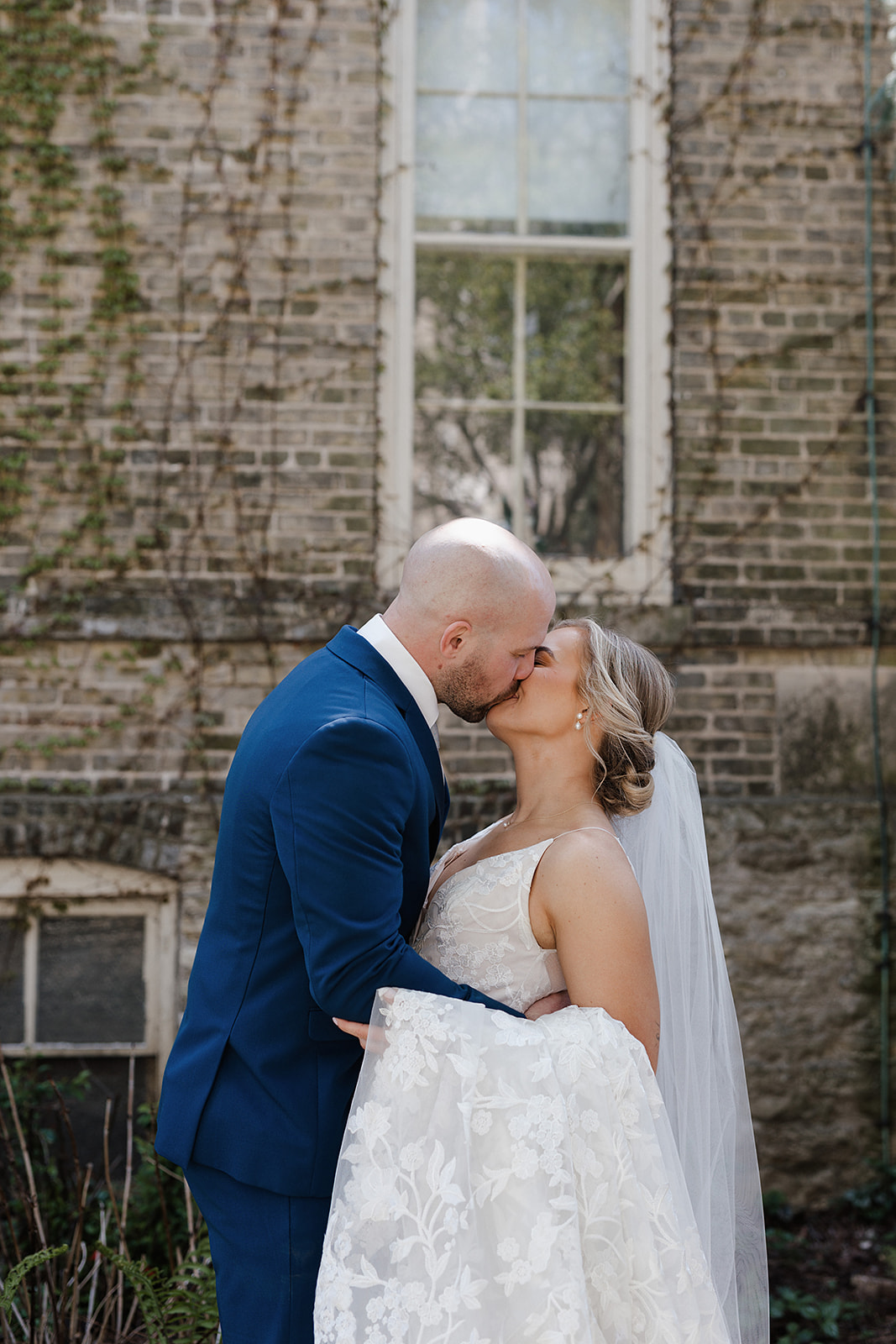 A bride and groom kissing during the portrait section of their wedding reception timeline