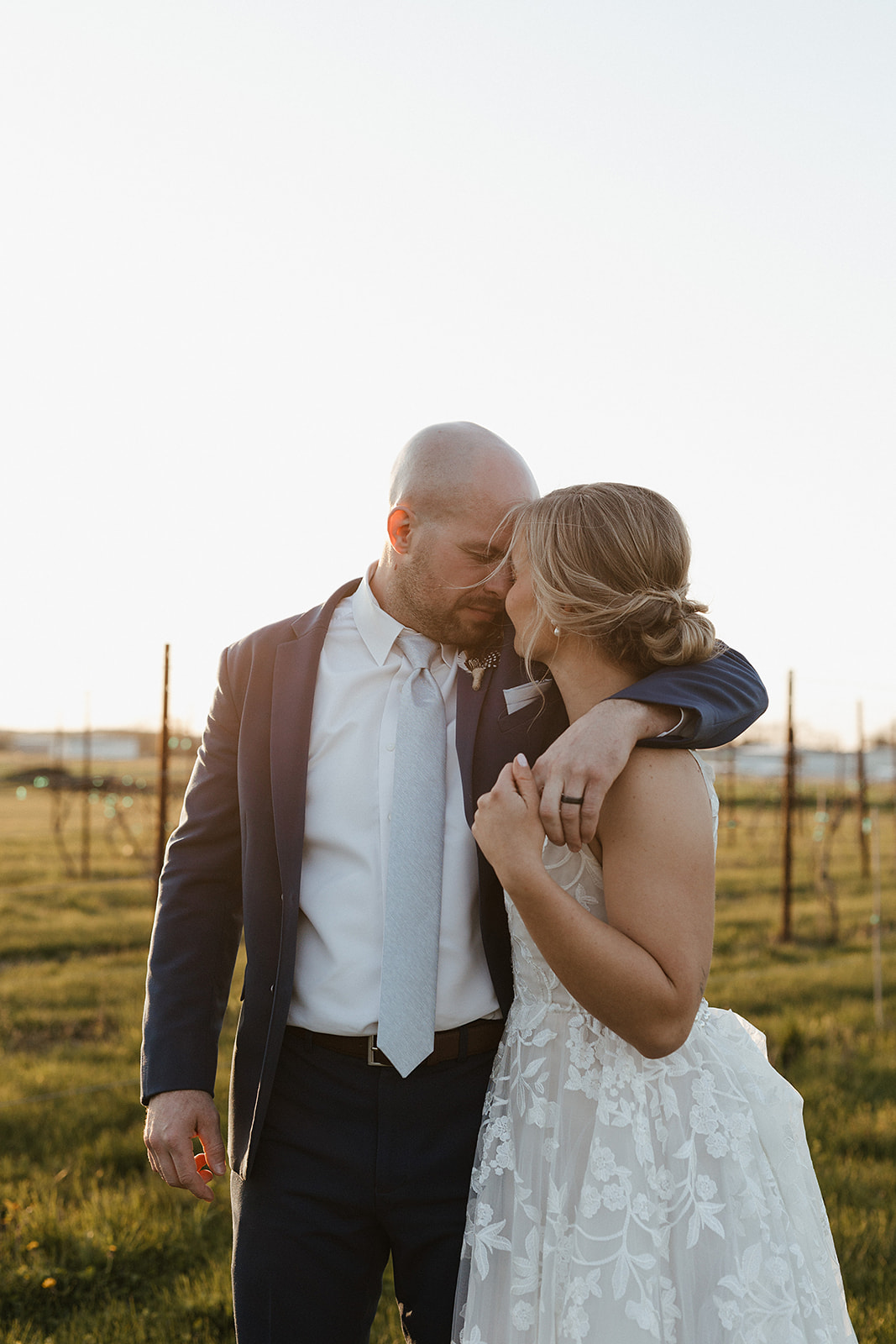 A bride and groom posing for sunset wedding photos
