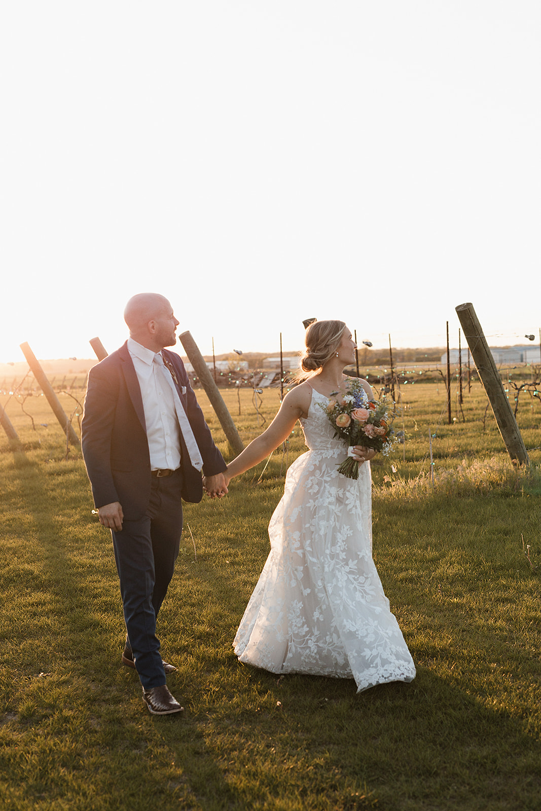 A bride and groom taking the sunset photos from their wedding reception timeline