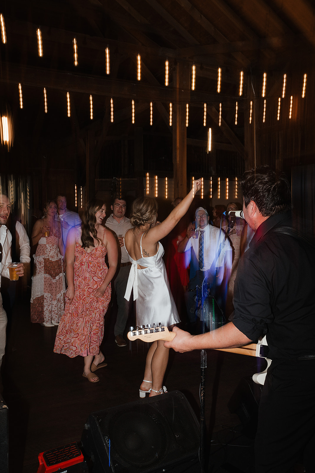 A candid wedding reception photo of a bride dancing