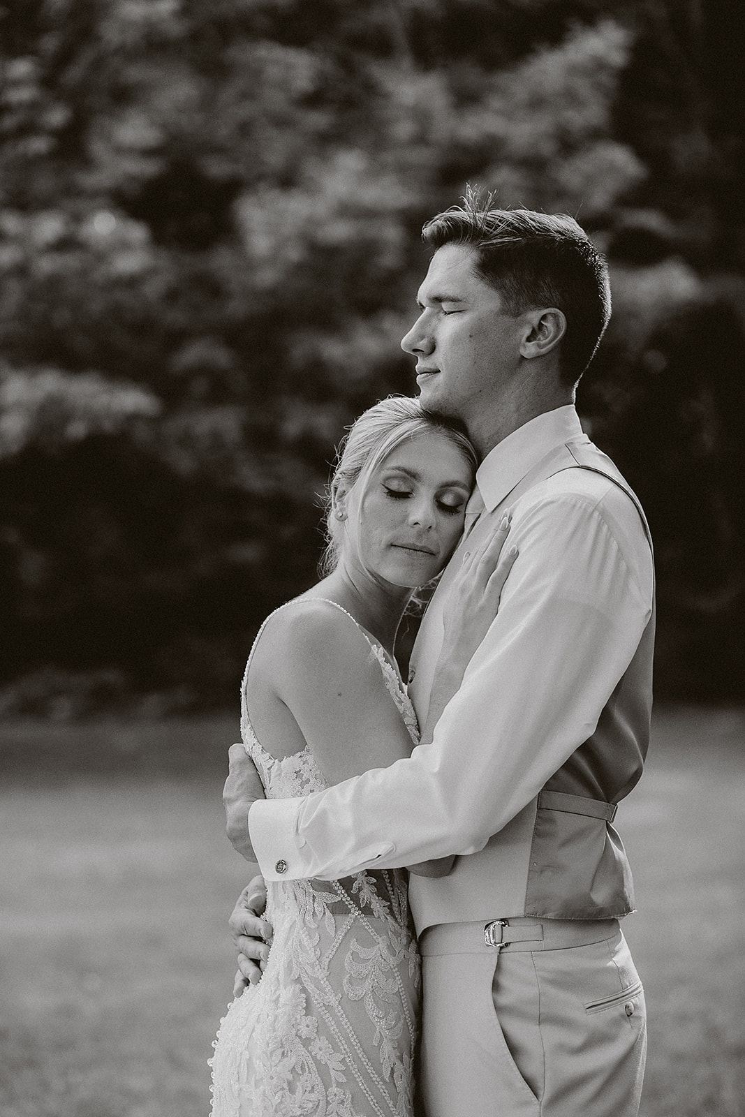 A bride and groom posing for black and white wedding photos