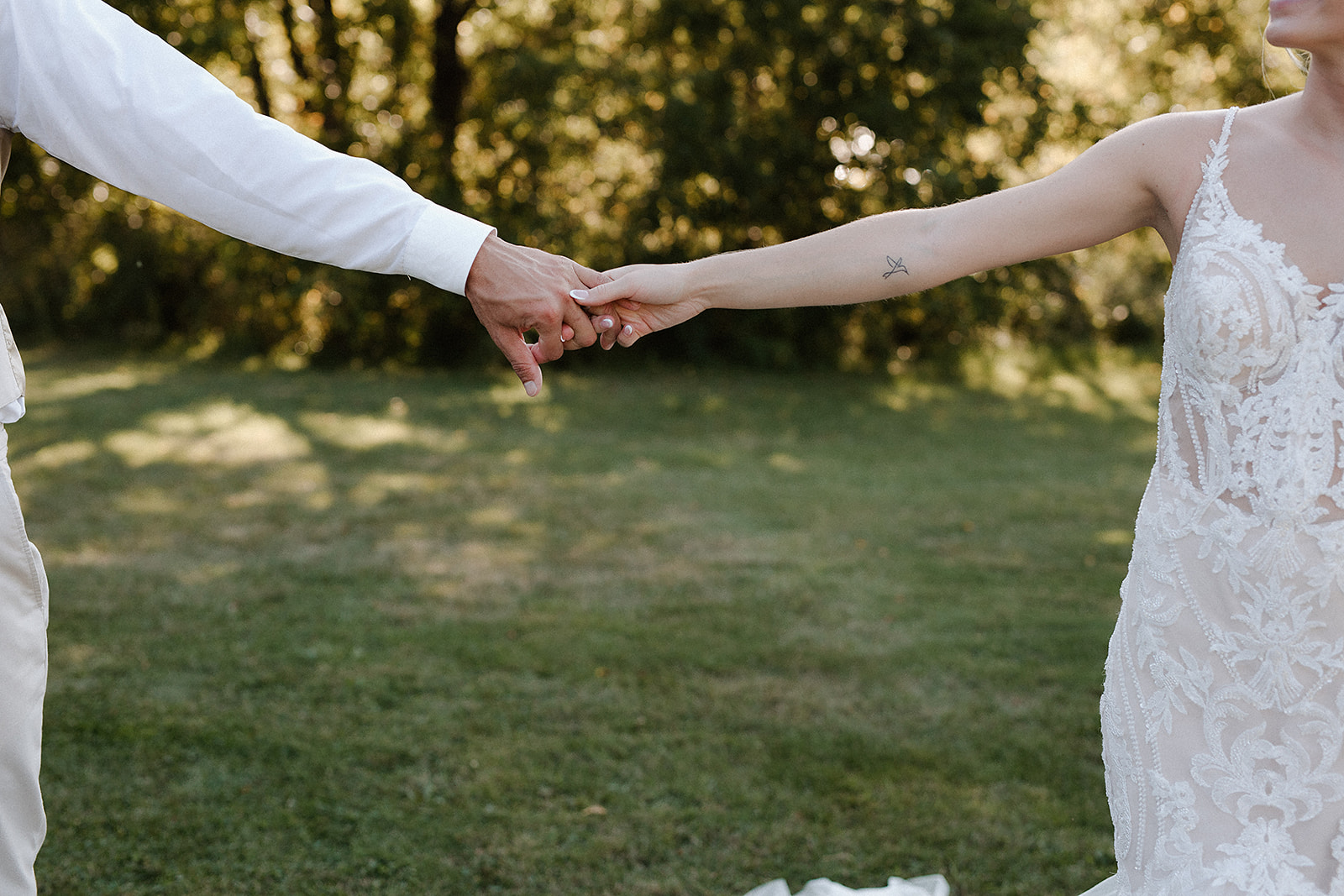 a bride and groom holding hands during sunset portraits