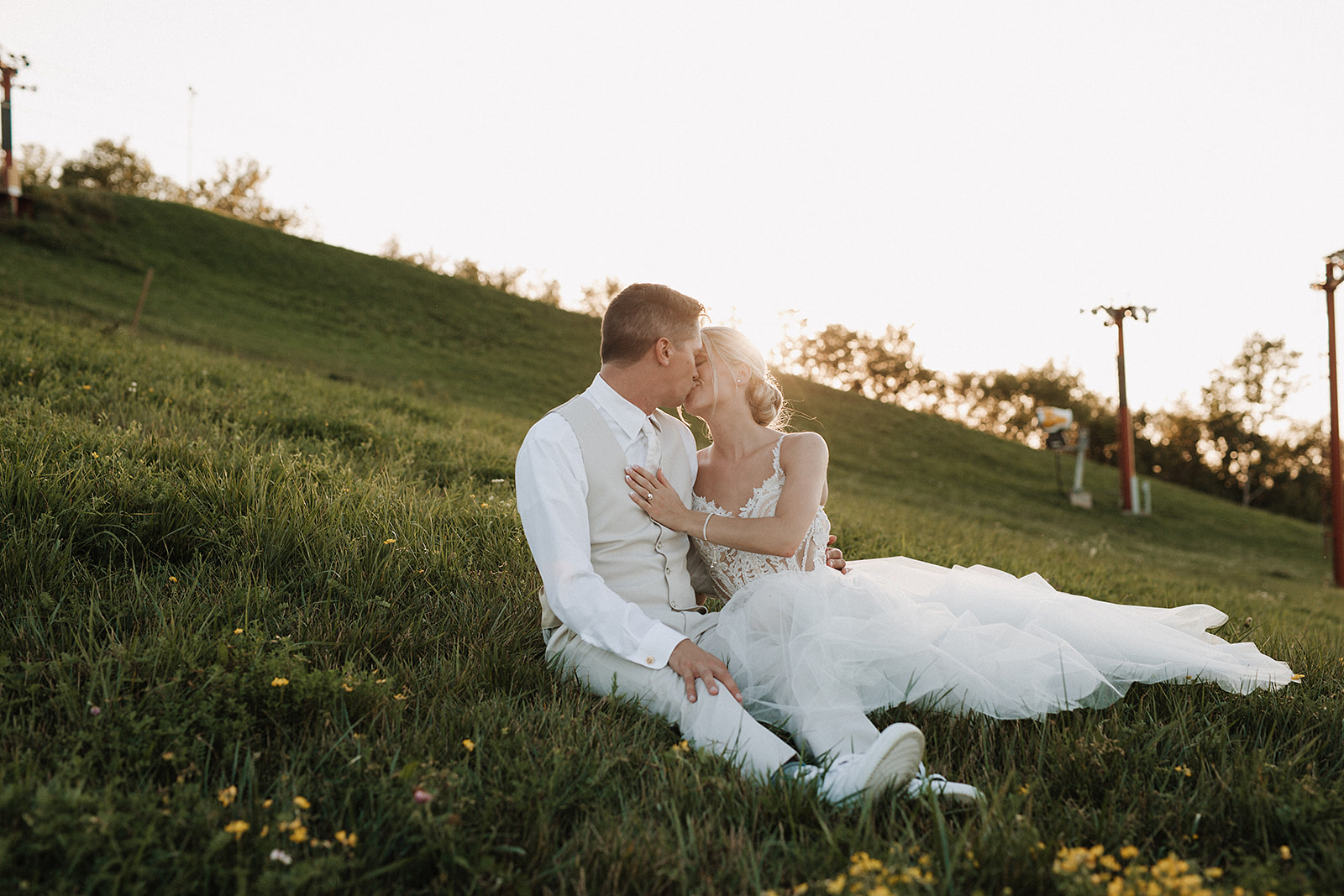 A bride and groom kissing during sunset portraits