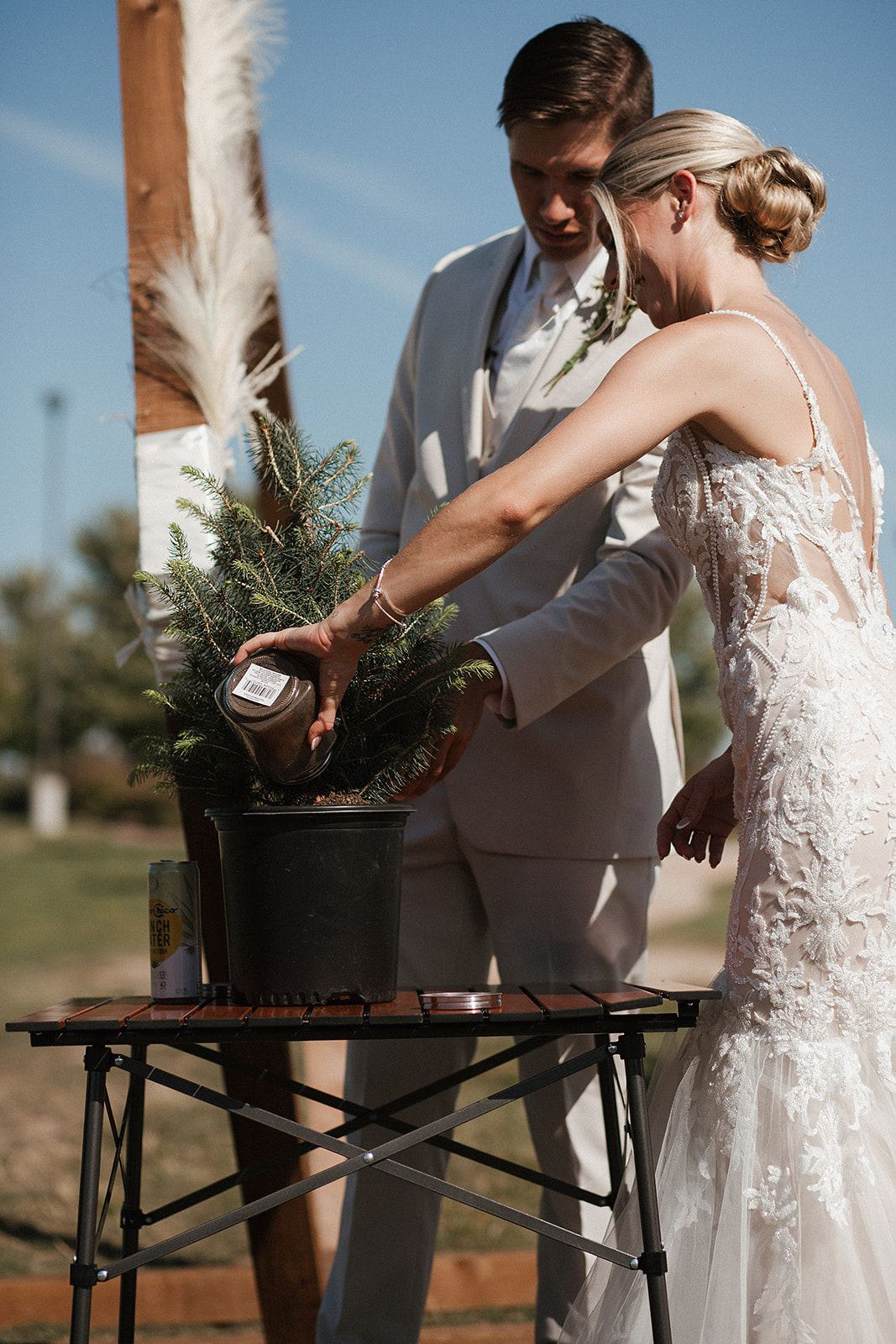 A bride and groom planting a tree during a wedding ceremony