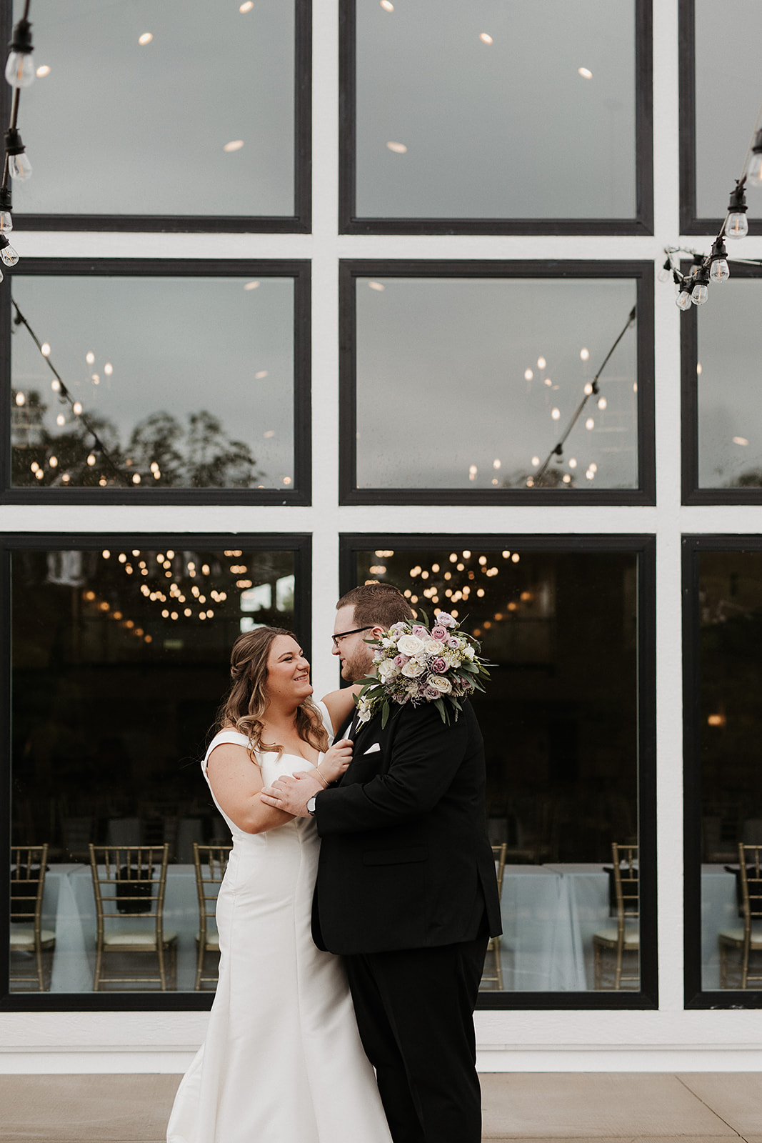 A bride and groom taking photos in front of their luxury wedding venue, the eloise
