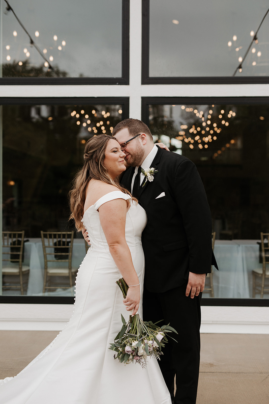 A bride and groom taking photos in front of their luxury wedding venue, the eloise