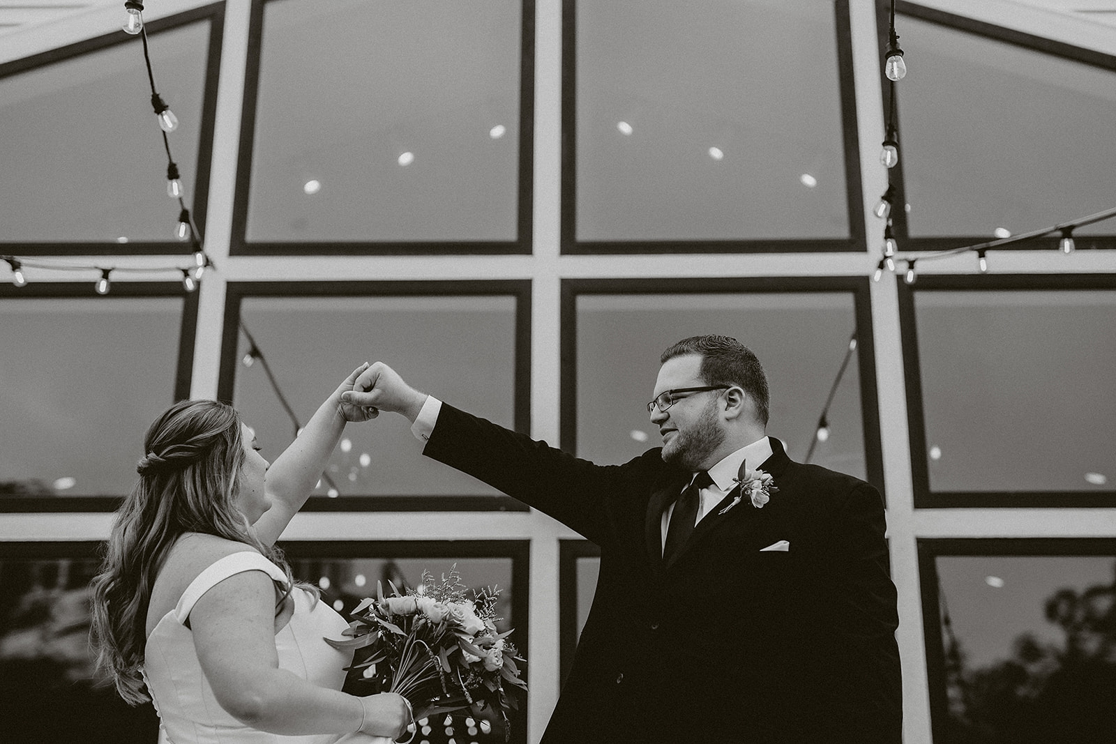 A bride and groom spinning outside of their wedding venue, the eloise