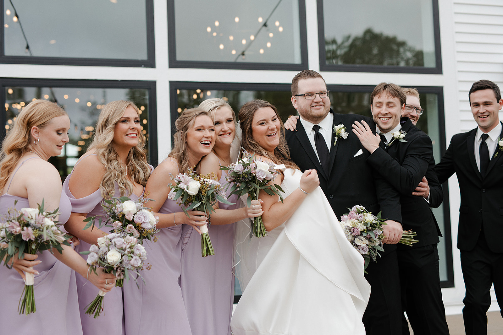 A wedding party posing for photos in front of the eloise