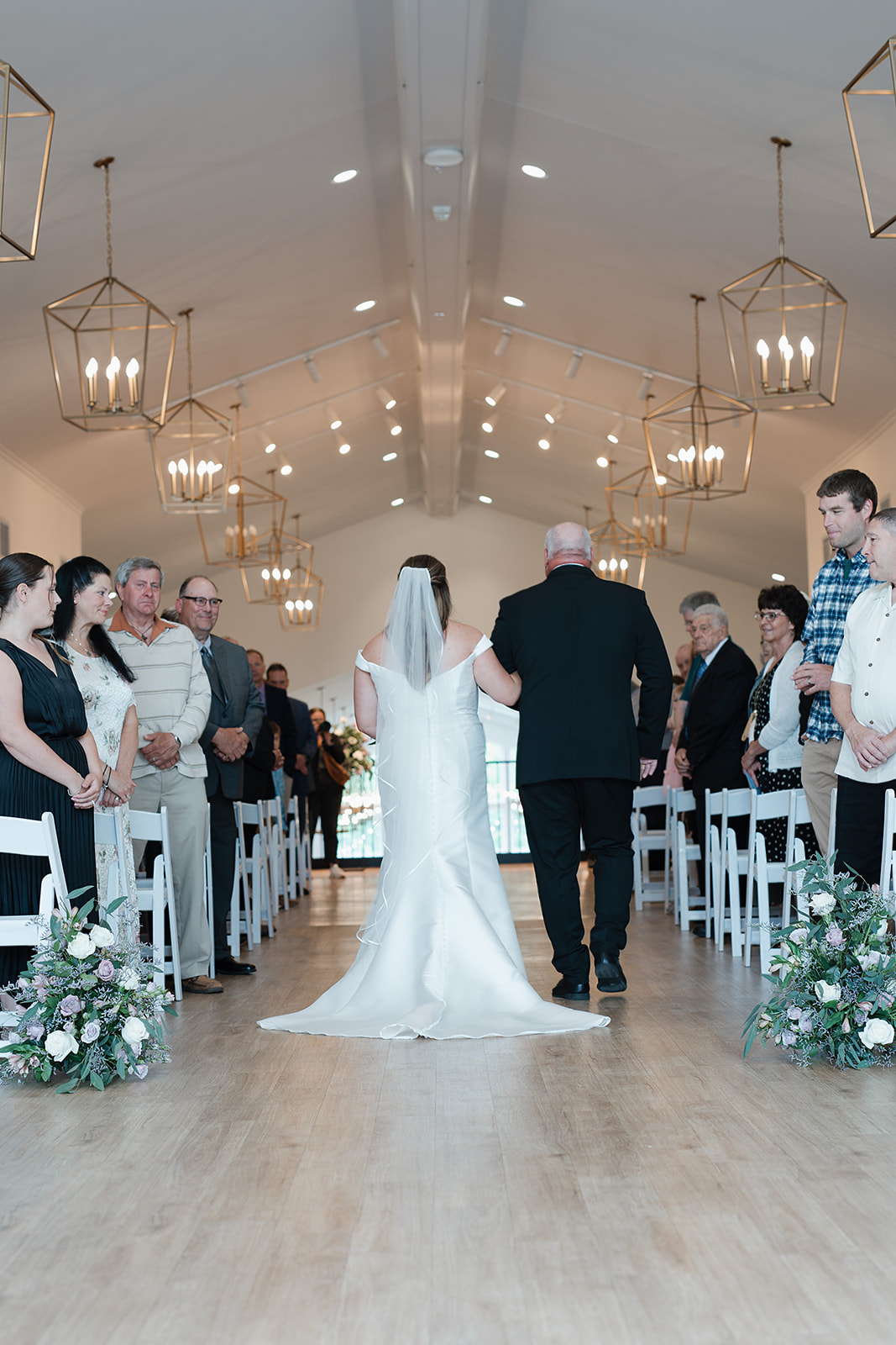 A bride walking down the aisle in her indoor wedding ceremony