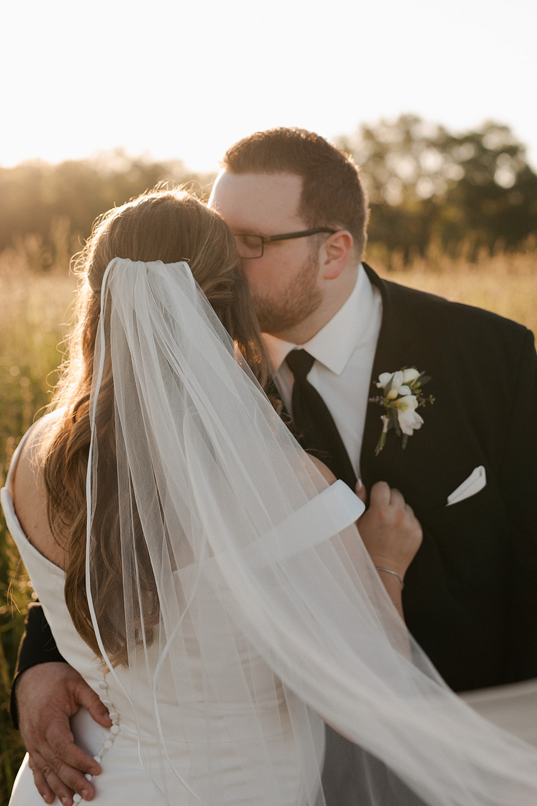  a bride and groom kissing during wedding portraits