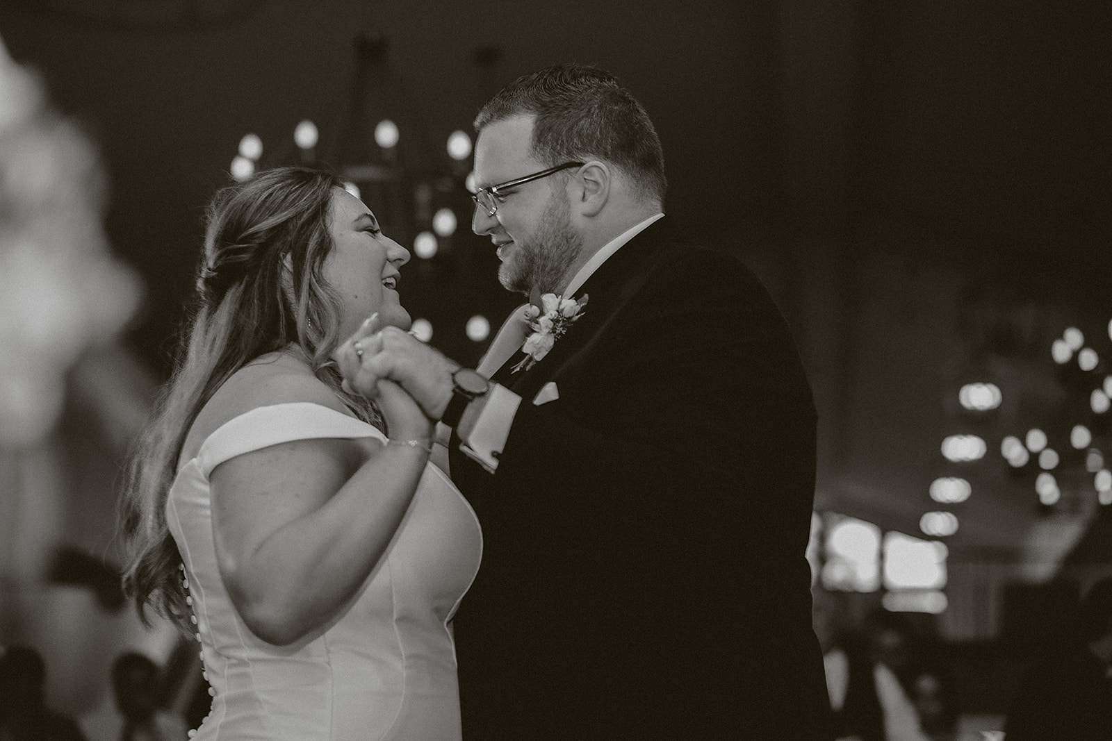 A black and white photo of a bride and groom during their first dance