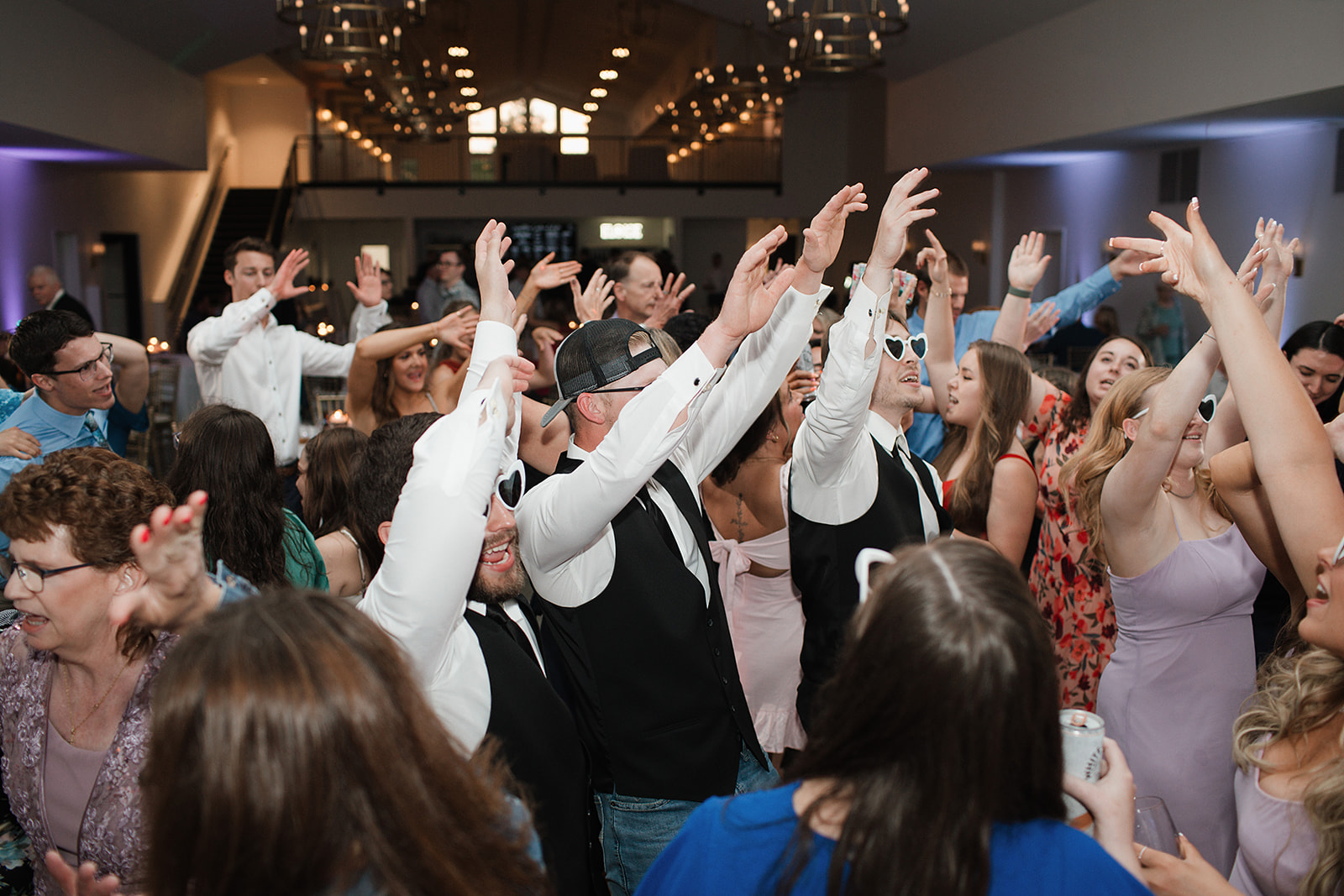 A candid wedding reception photo of guests dancing