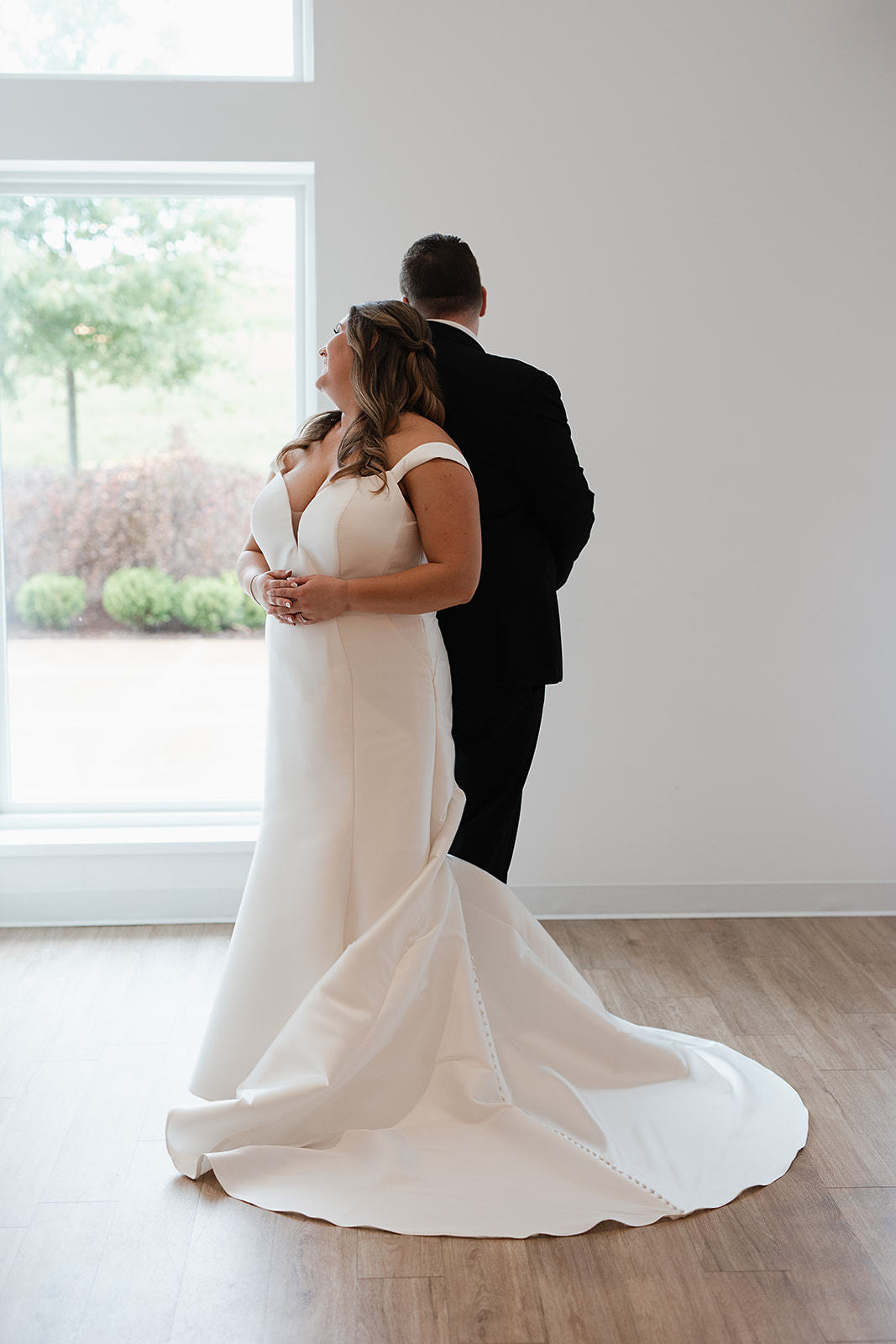 A couple standing back-to-back before their first look