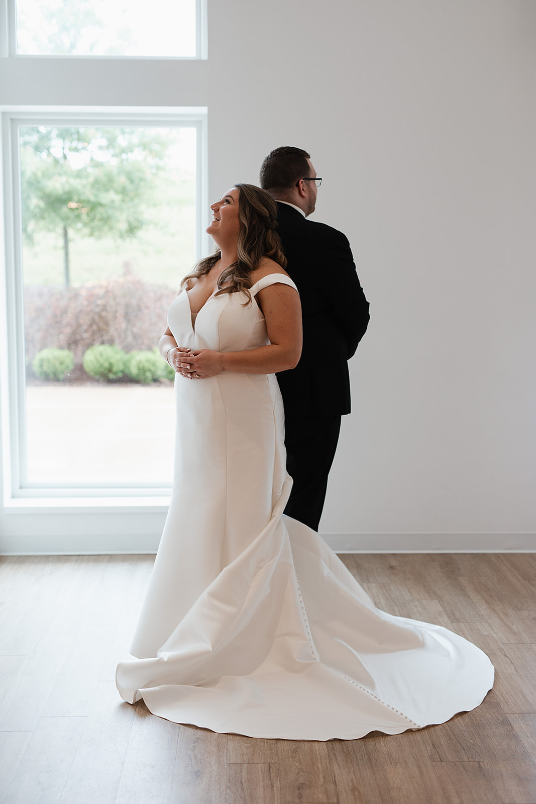 A couple standing back-to-back before their first look